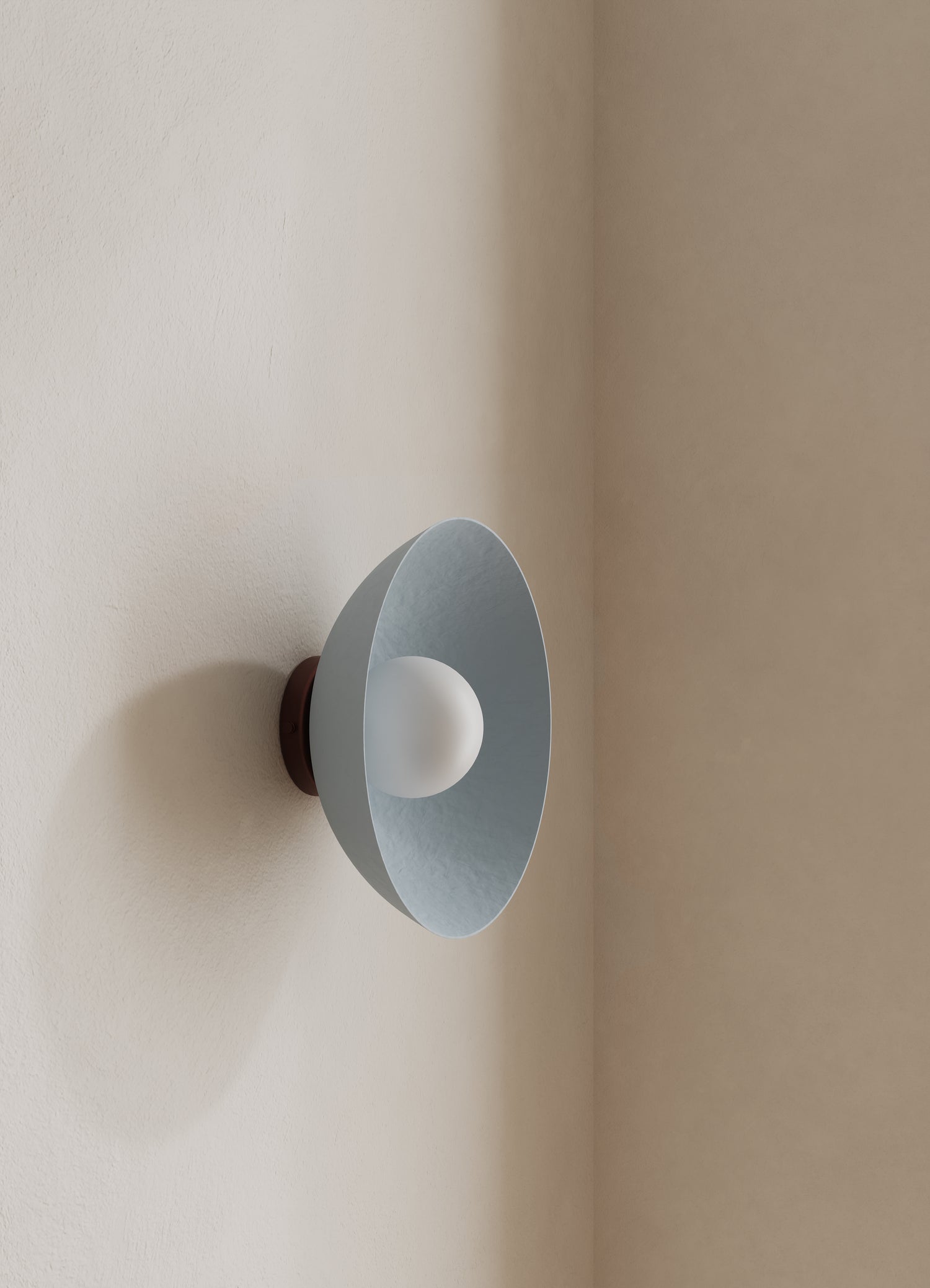 Wall-mounted light fixture with a light blue shade on a neutral wall.