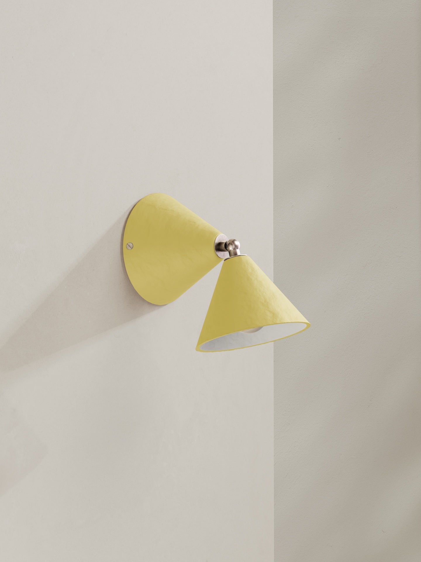 Hardwired Rotor wall light - a conical shape wall light, hand-painted in light yellow colour with nickel finishes.