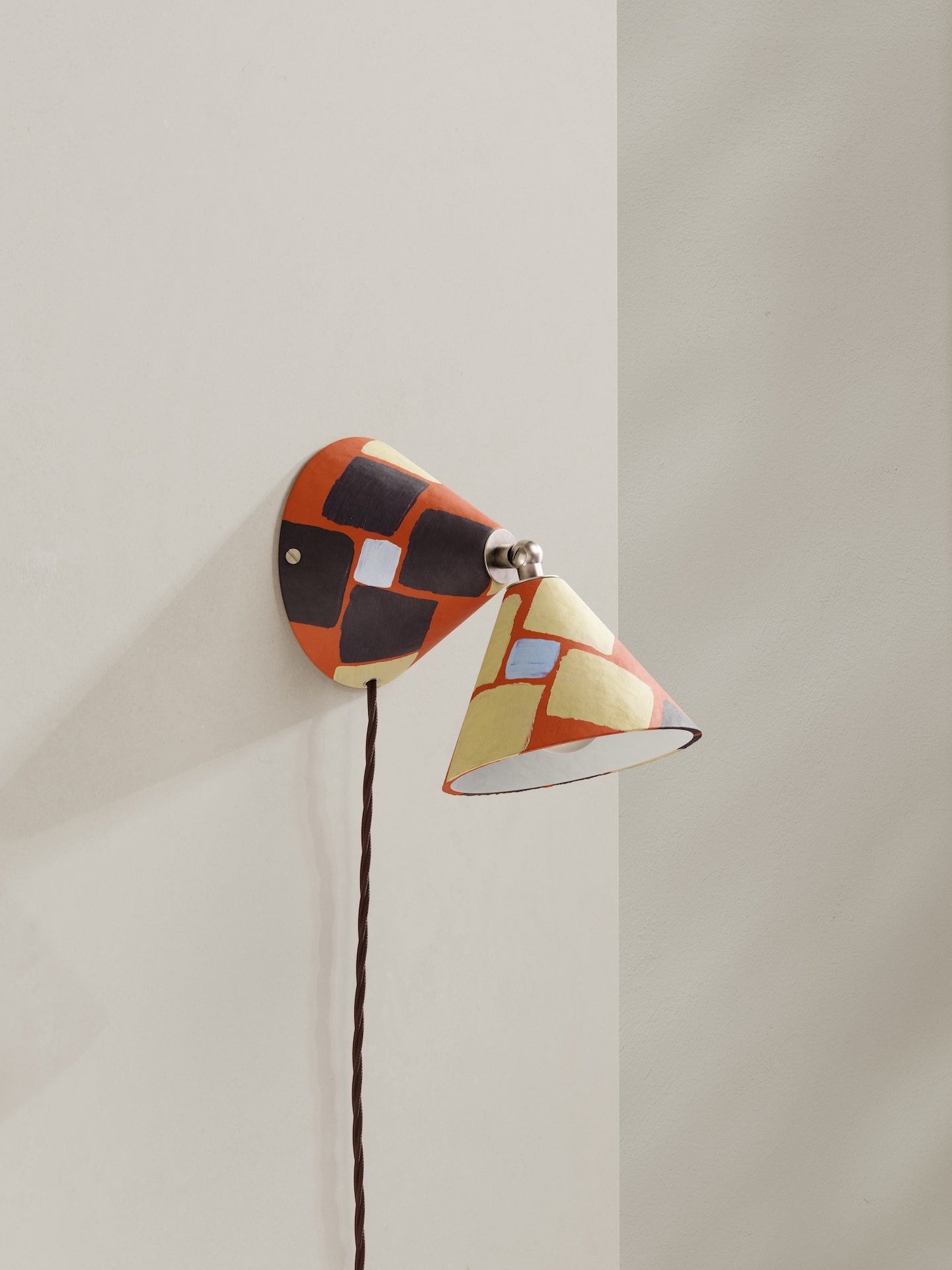 Plug-in Rotor wall light -  - a conical shaped plug-in wall light, in hand-painted paper pulp, mosaic pattern with orange base colour, brown and light blue and light yellow accents and brown flex.