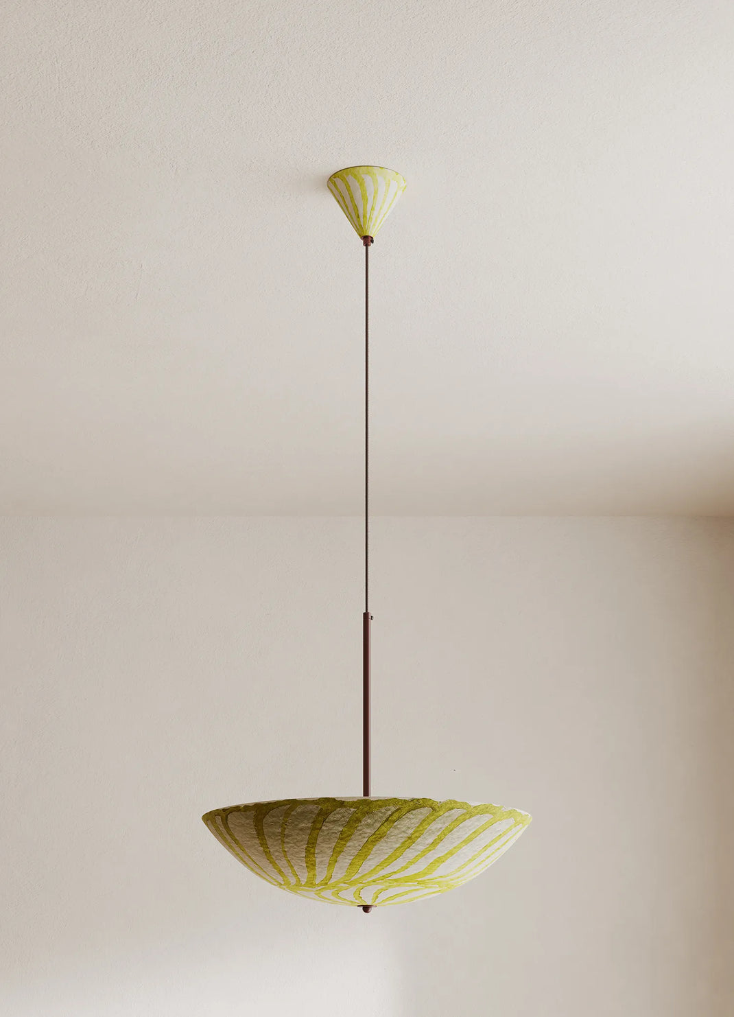 Yellow and white pendant light fixture hanging against a plain wall.