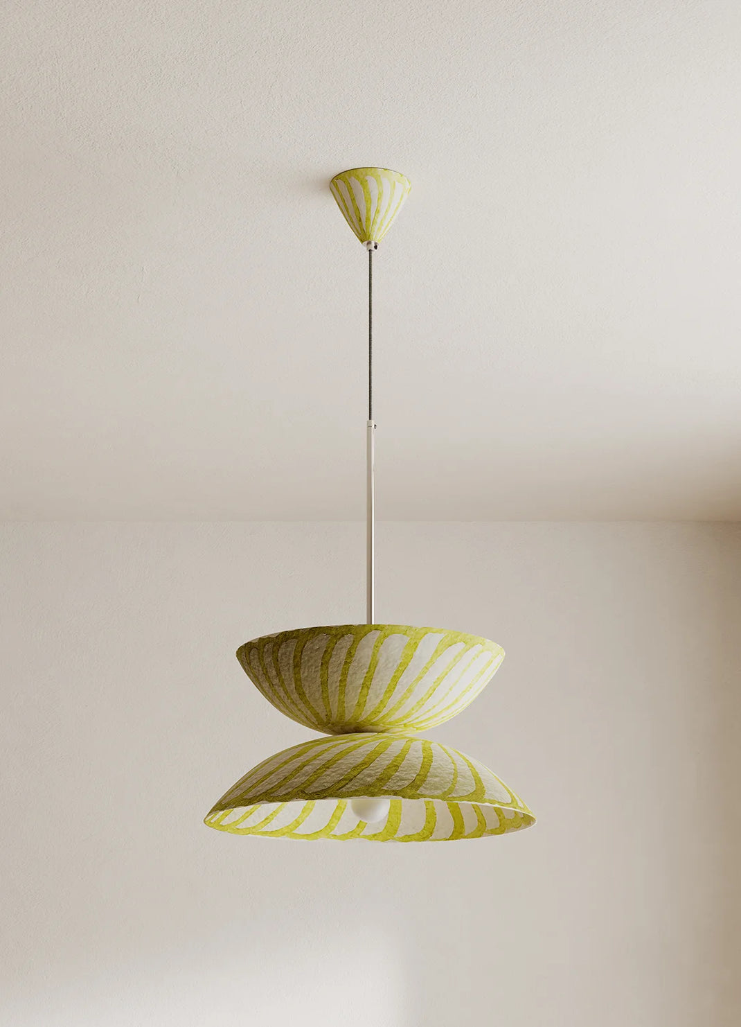 A modern two-tiered pendant light with a yellow and white shade, suspended by a slim metal rod from a matching ceiling canopy against a plain off-white wall.