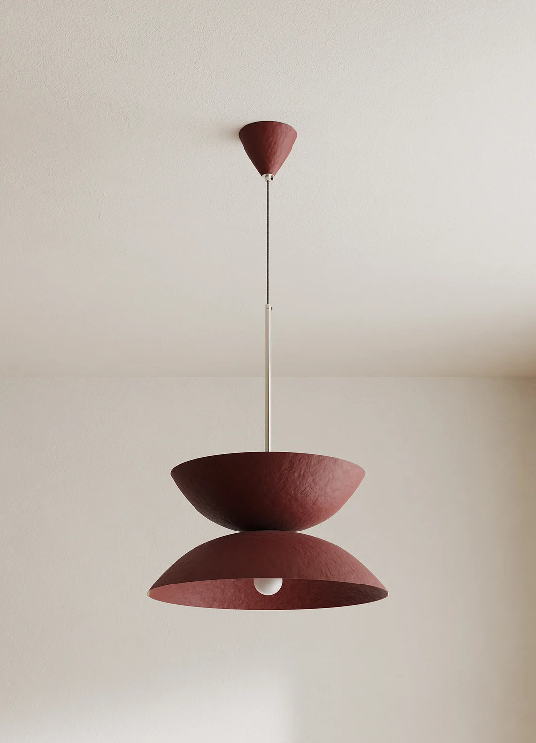 Modern pendant light with two layered shades on a neutral background