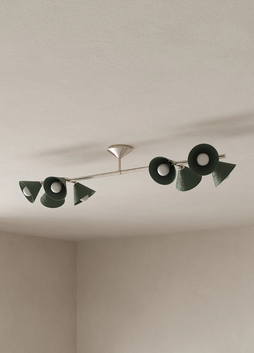 A modern ceiling-mounted light fixture with eight dark green cone-shaped shades and a silver metal arm, installed on a textured off-white ceiling.