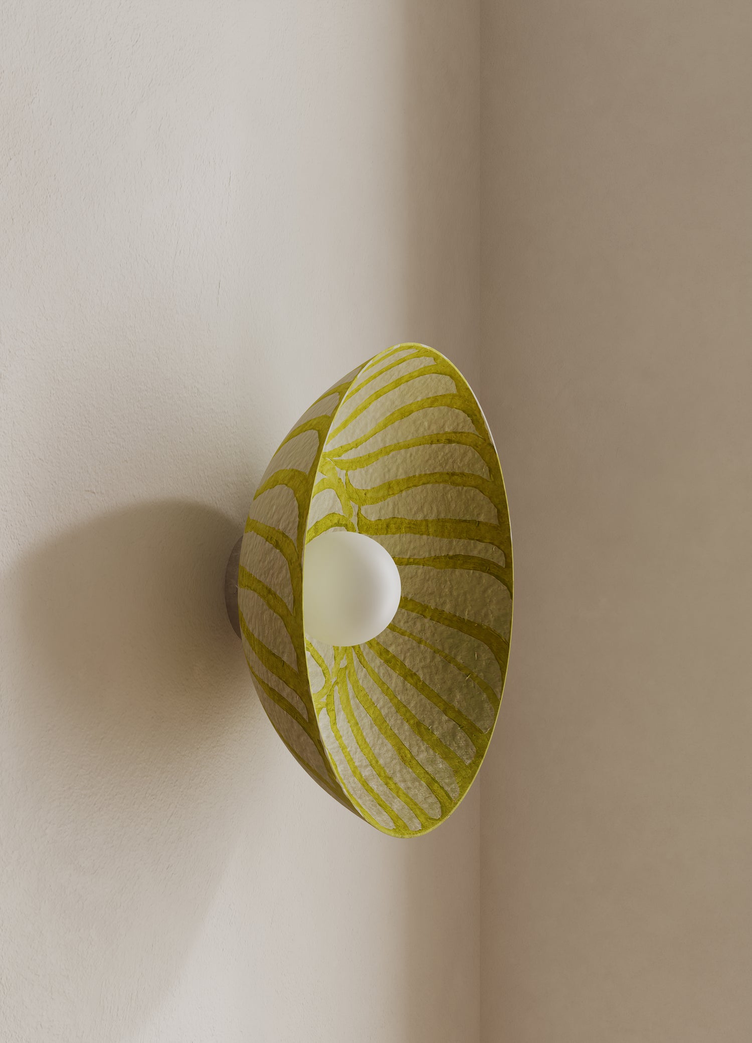Wall light fixture with a yellow patterned shade on a neutral wall