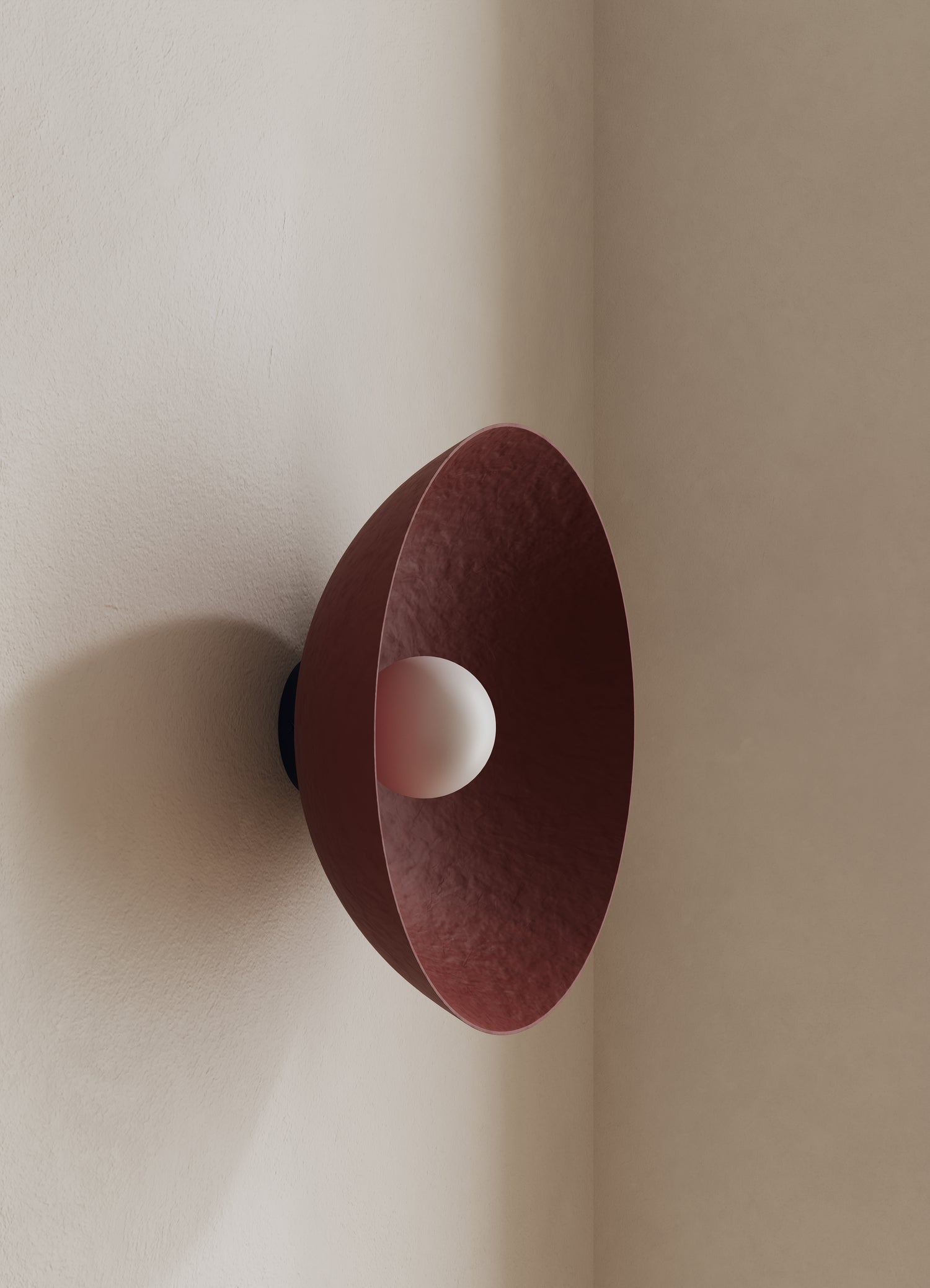 Wall-mounted light fixture with a burgundy shade on a neutral wall.