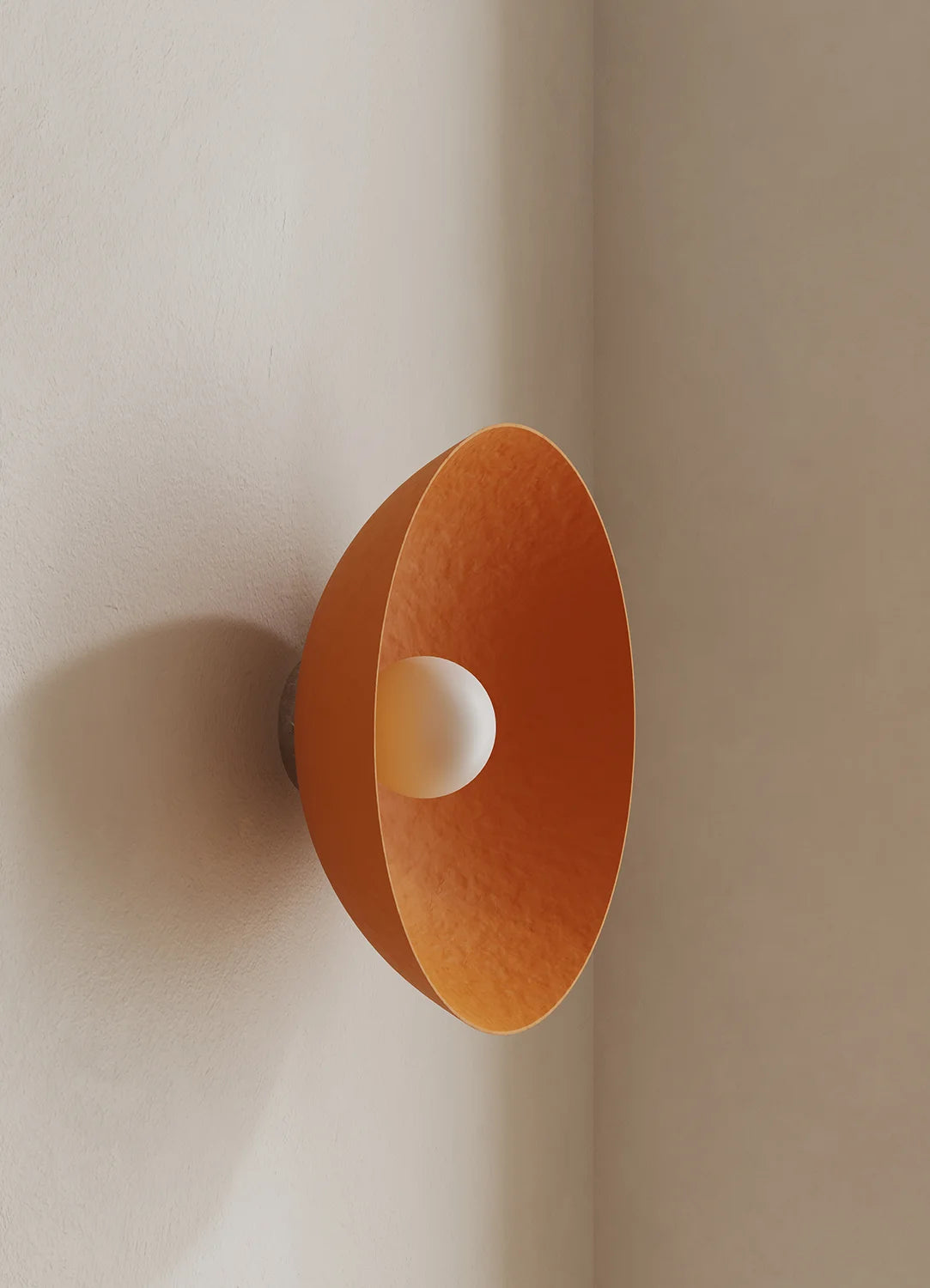 Orange wall-mounted lamp on a plain wall