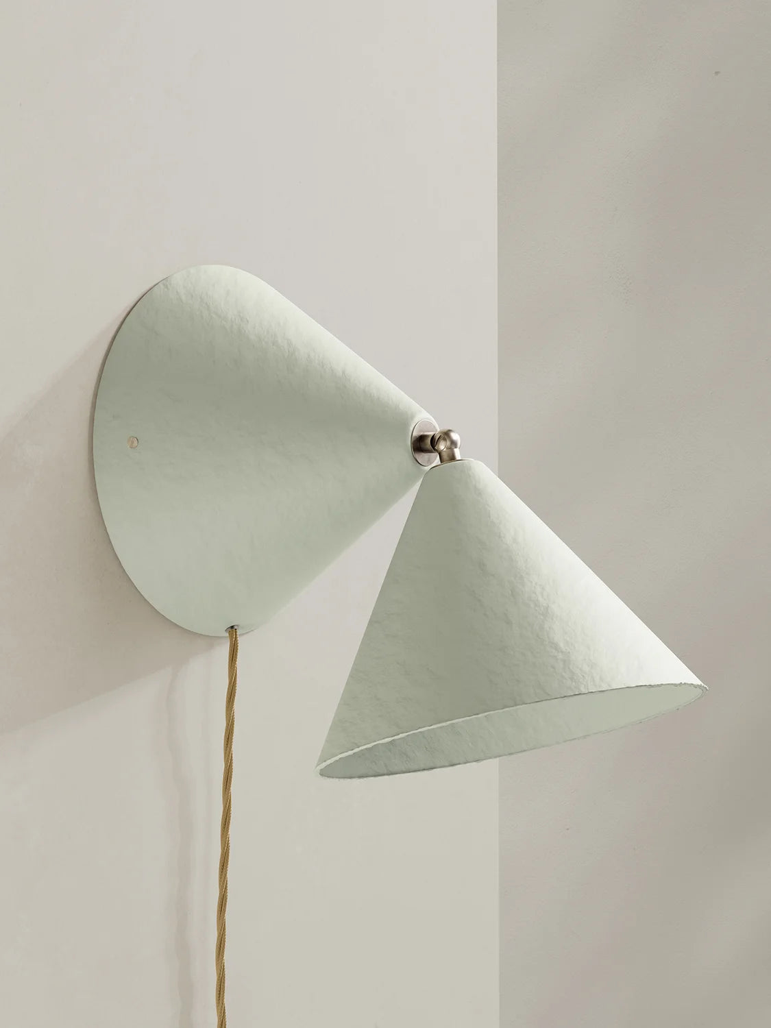 Off-white wall lamp with a cone-shaped shade on a neutral background