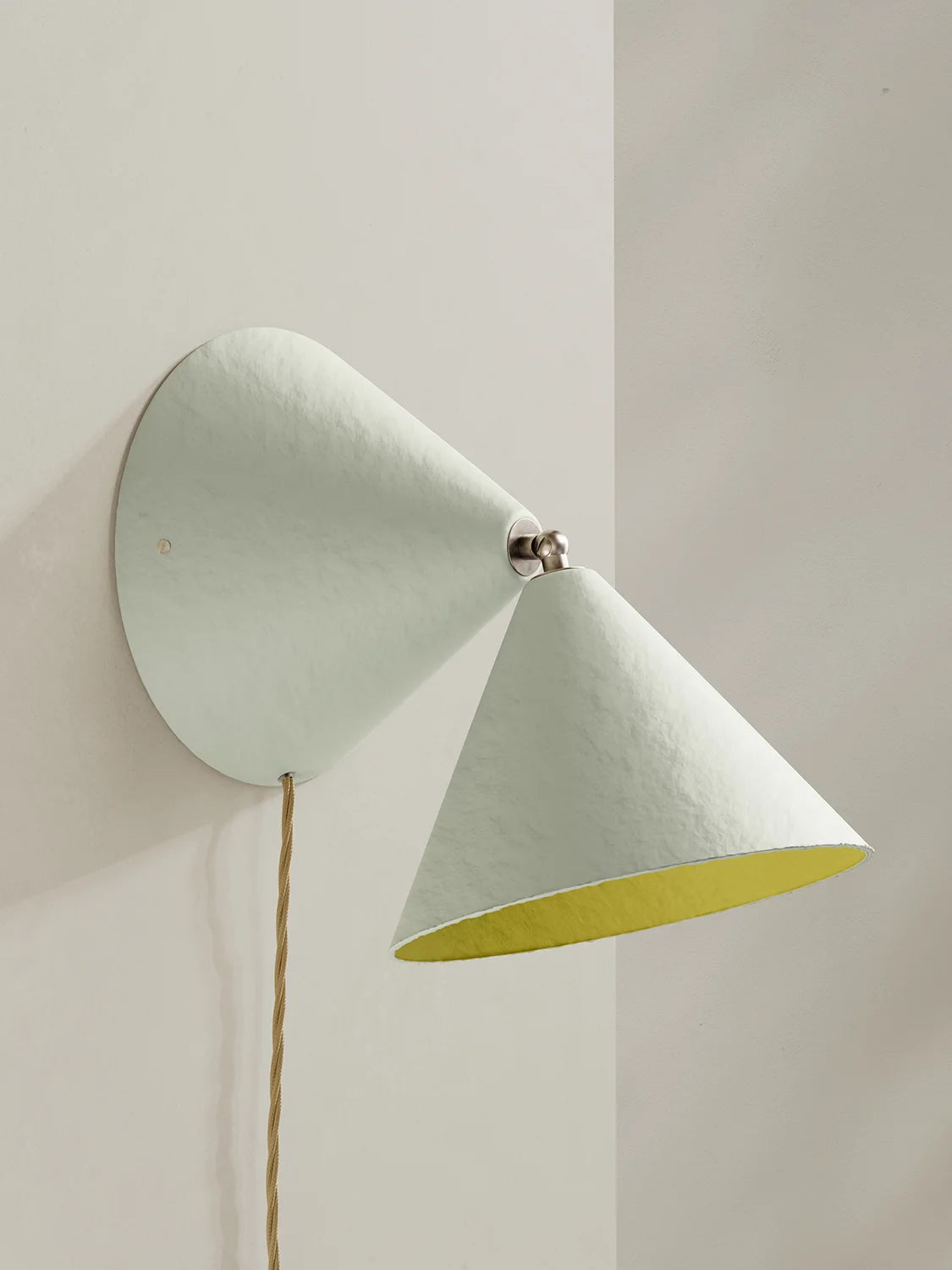 Wall-mounted lamp with a white exterior and yellow interior on a plain background