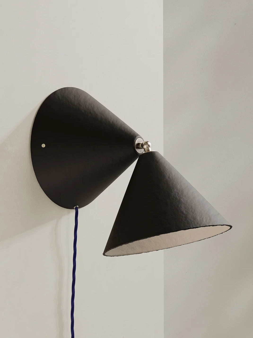 Dark brown wall-mounted lamp with a cone-shaped shade on a neutral background