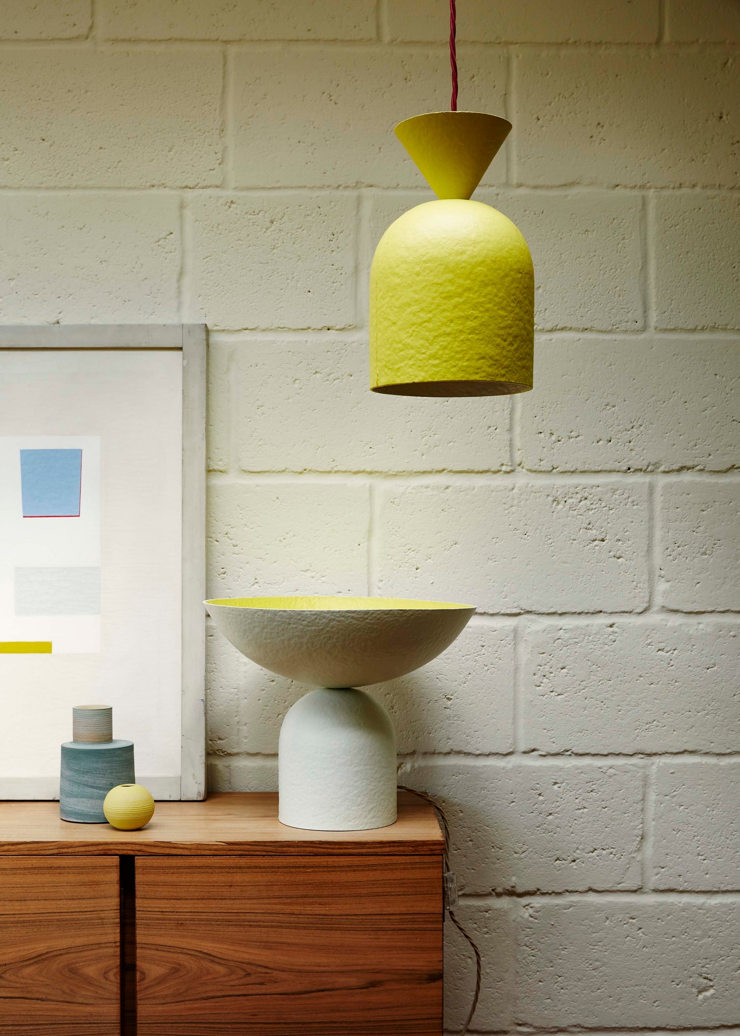 Bell Pendant ceiling light in bright yellow and Satellite table lamp in off-white shown in a living room interior