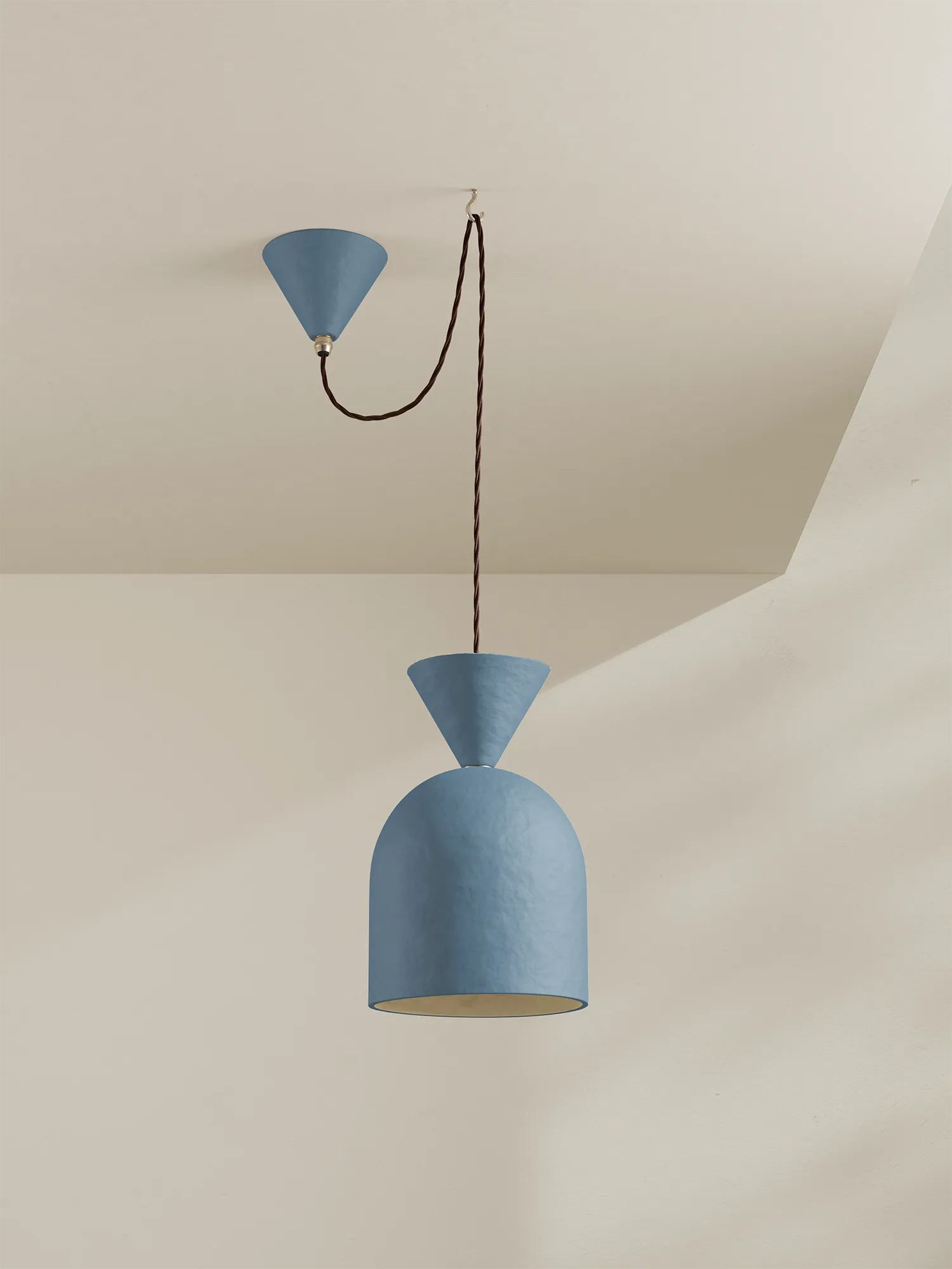 A blue pendant with brown flex against a grey background