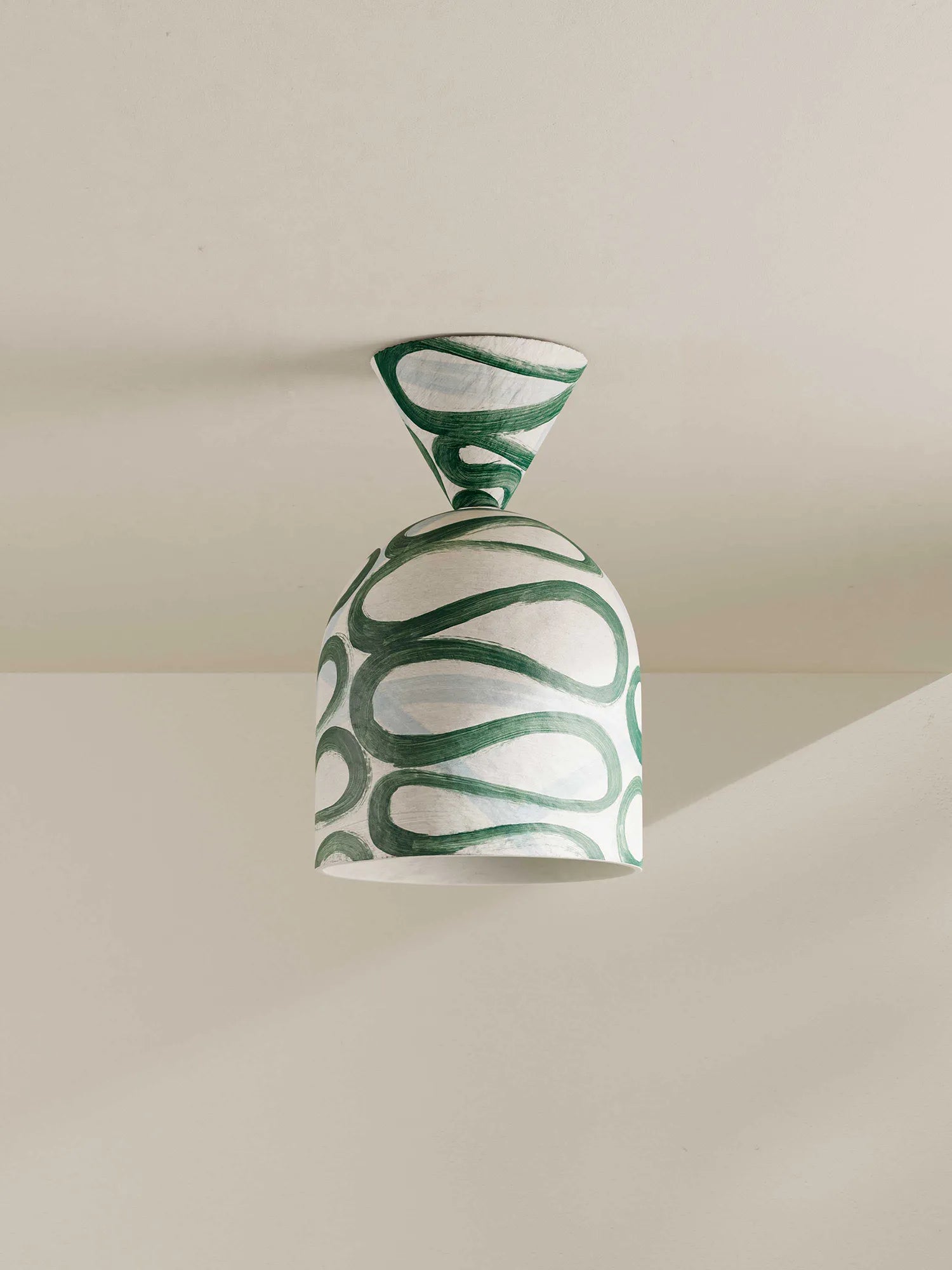 Decorative ceiling flush mount with green and white pattern on a neutral background