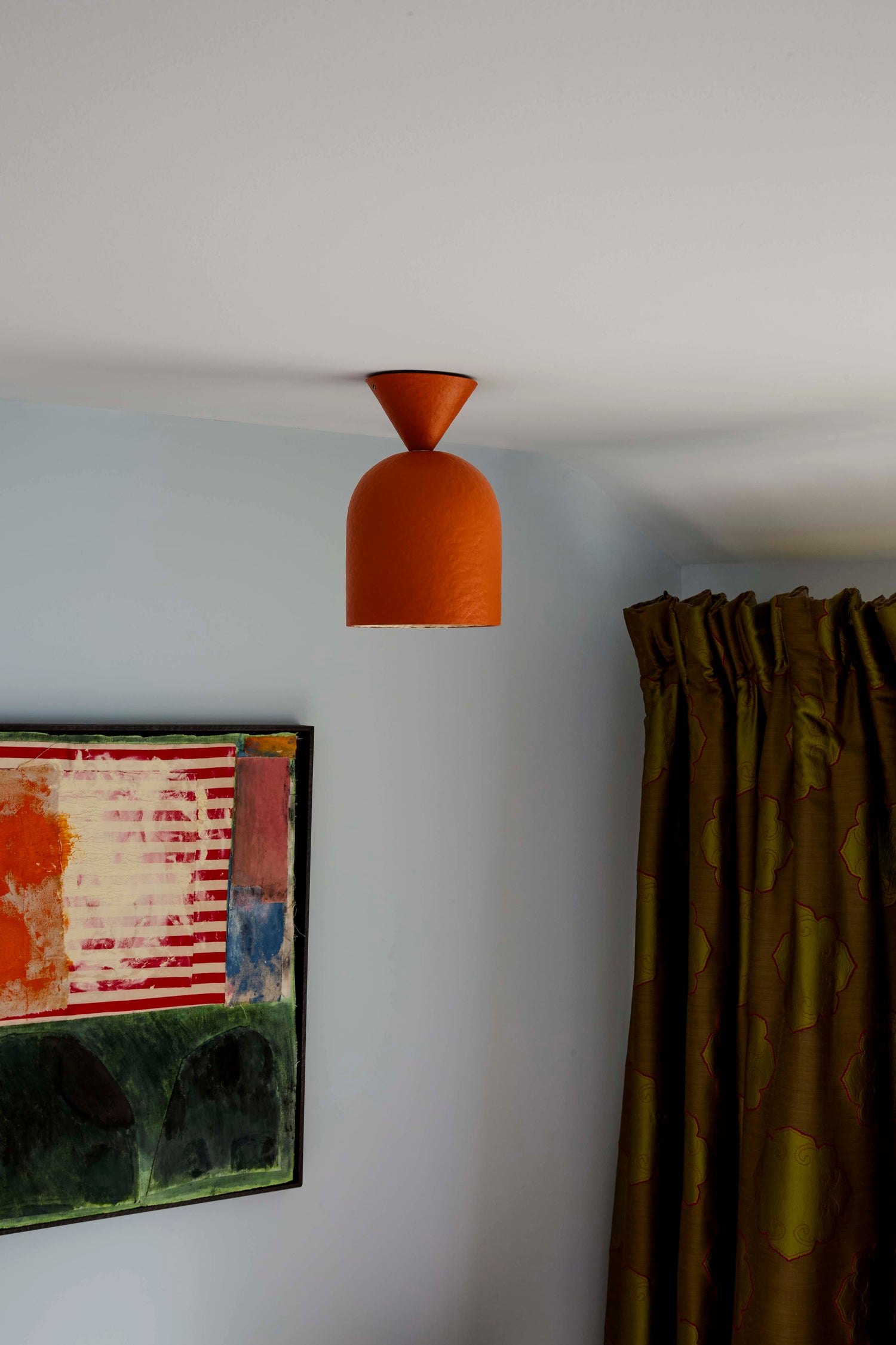 Bell Surface Mount ceiling light hand-painted in orange-red colour shown in a bedroom interior