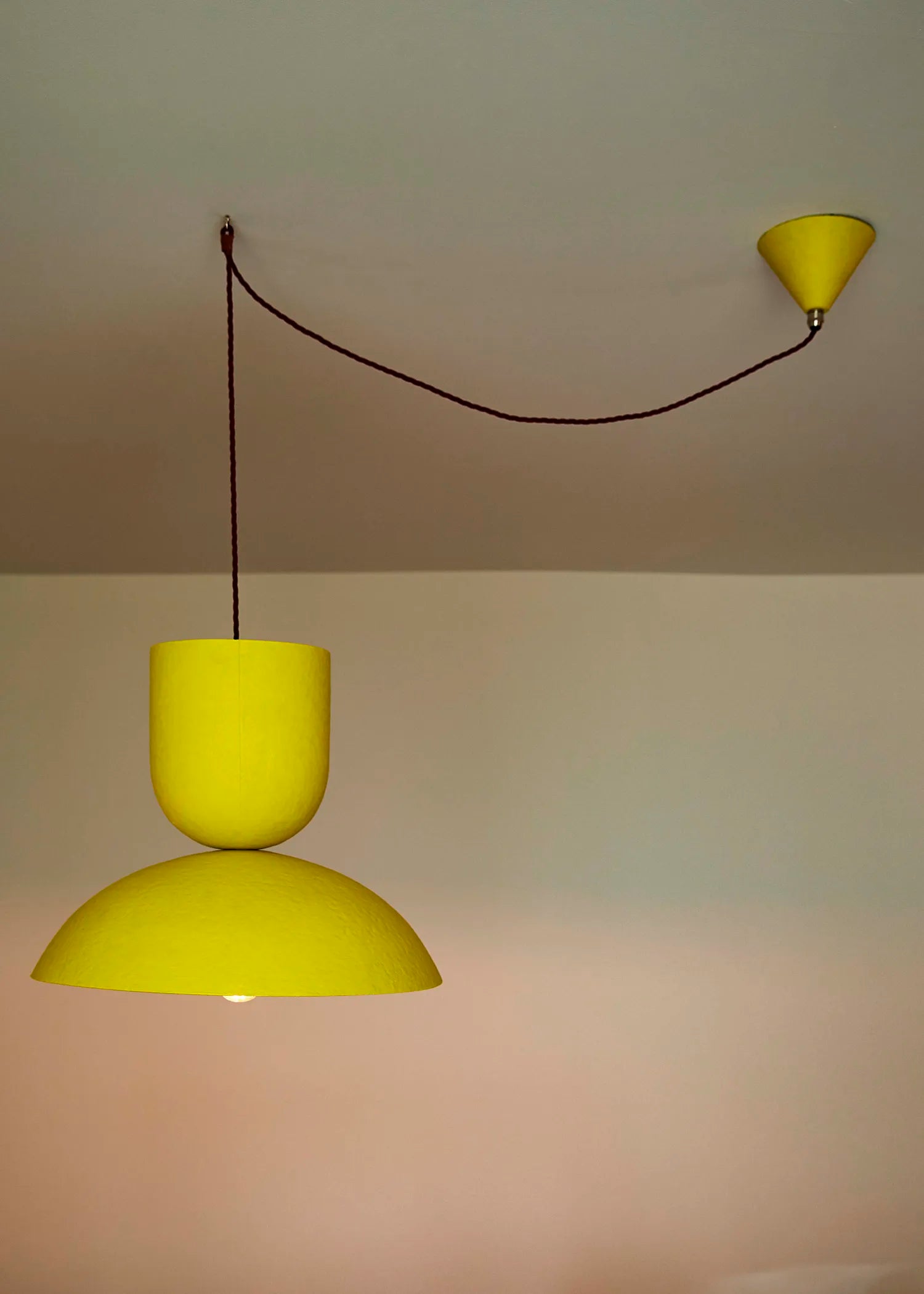 Yellow pendant light fixture on a plain wall