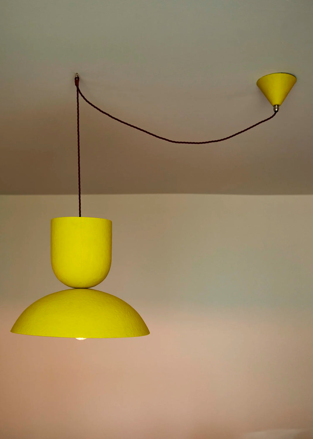 Yellow pendant light fixture on a plain wall