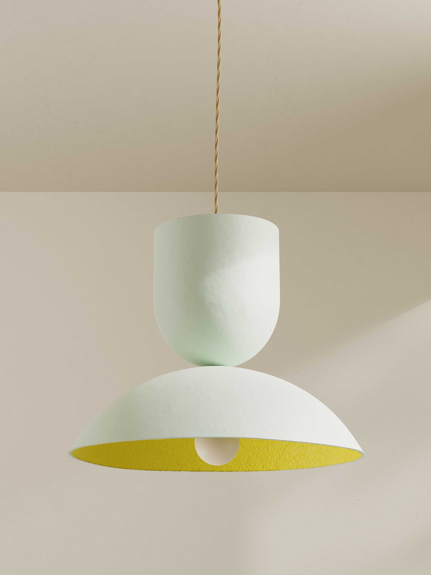 Buoy pendant, a large ceiling light made of paper pulp and hand-painted in off-white exterior and bright yellow shade interior