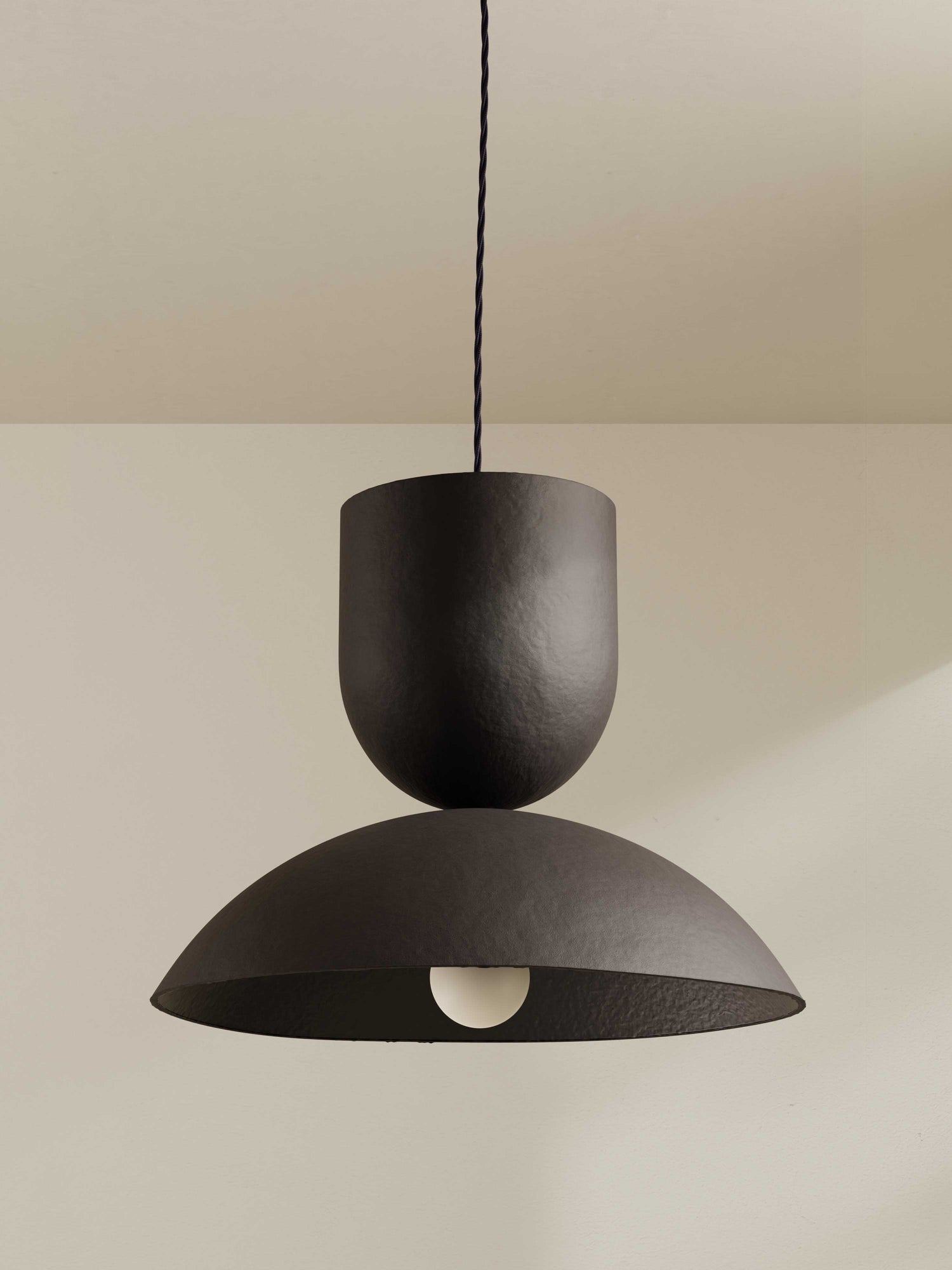 Buoy pendant, a large ceiling light made of paper pulp and hand-painted in dark brown.