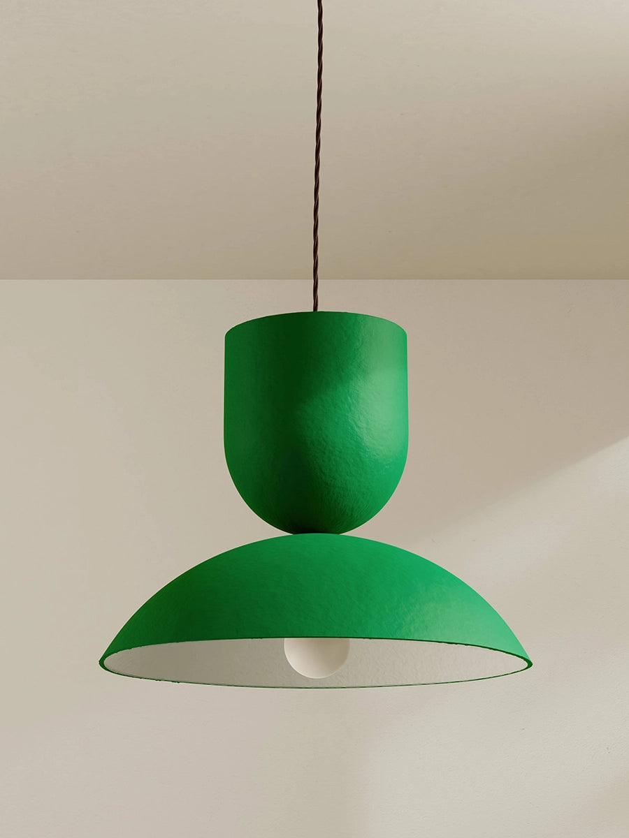Green pendant lamp hanging against a plain background
