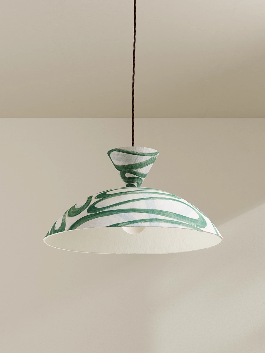 Green and white pendant light against a beige wall