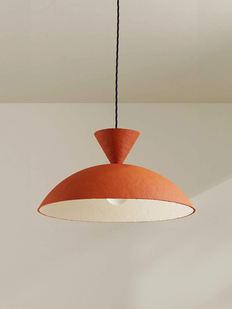 Orange pendant light hanging against a plain wall