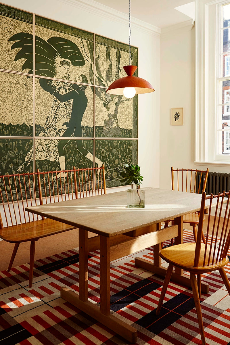 Dining room with wooden table and chairs, large wall mural, and pendant light.