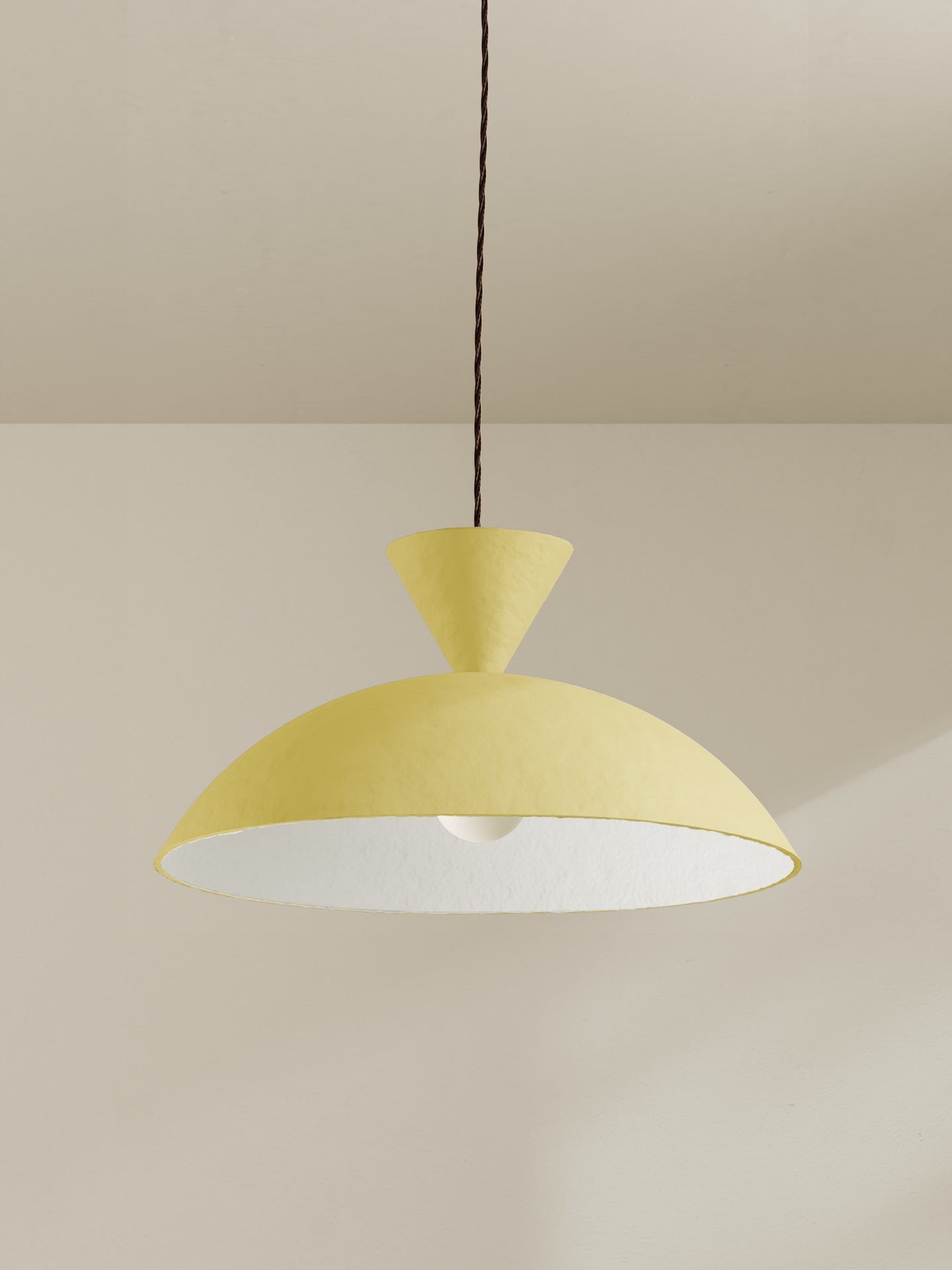 Cloche pendant, a ceiling light with a wide domed shade, made of paper pulp and hand-painted in sherbet yellow.