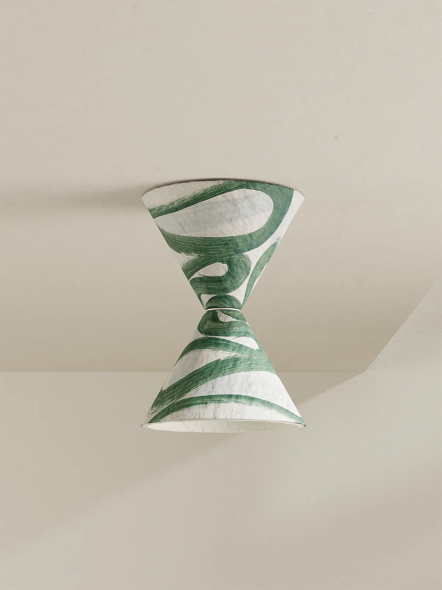 A modern hourglass-shaped ceiling light with a green and white abstract patterned shade, suspended against a minimalist beige wall and ceiling.