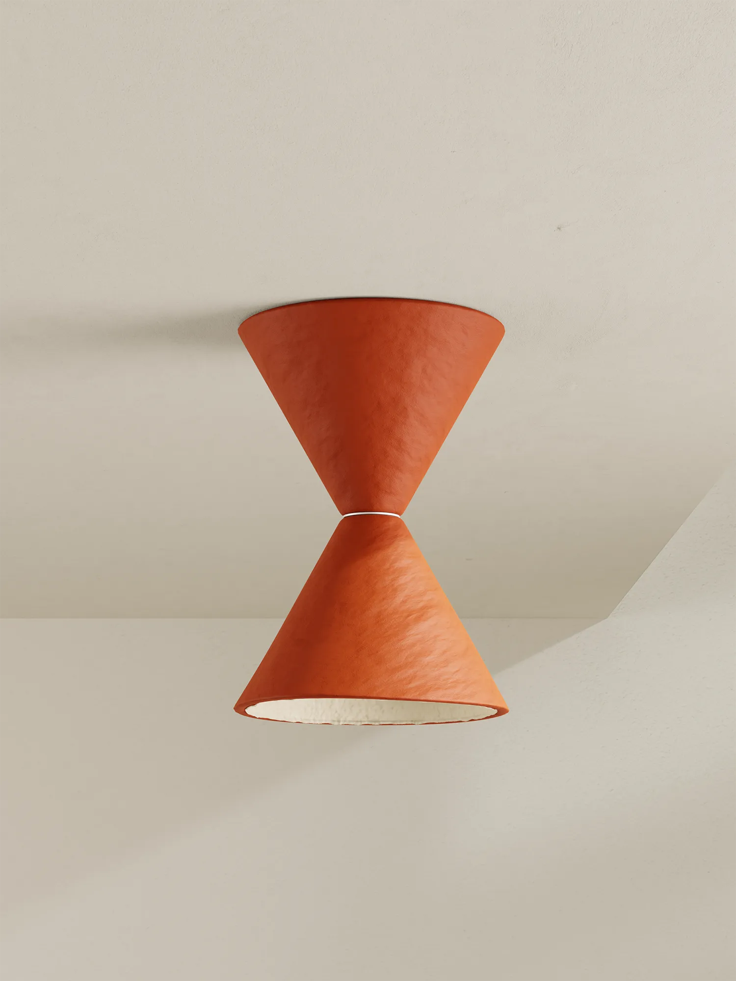 An hourglass-shaped surface mount light with textured terracotta orange shades, against a minimalist off-white wall and ceiling.