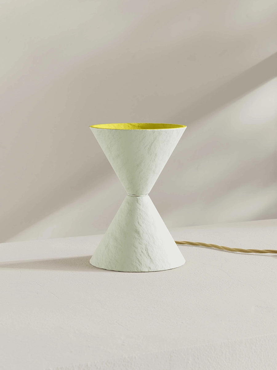 Small uplighter table lamp in white with a yellow interior.