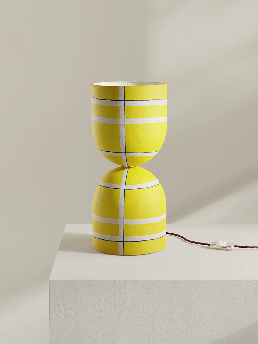 Yellow lamp with white stripes on a light gray background