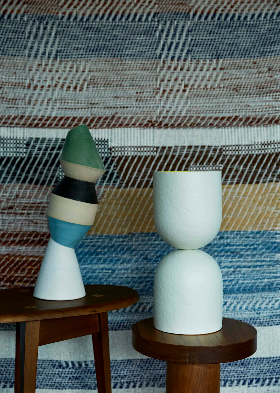 A white table lamp on a wooden stand against a plaid fabric background