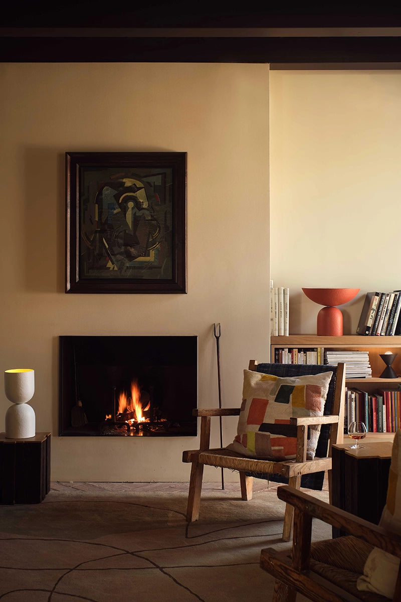 Living room with fireplace, table lamps, chairs, and books