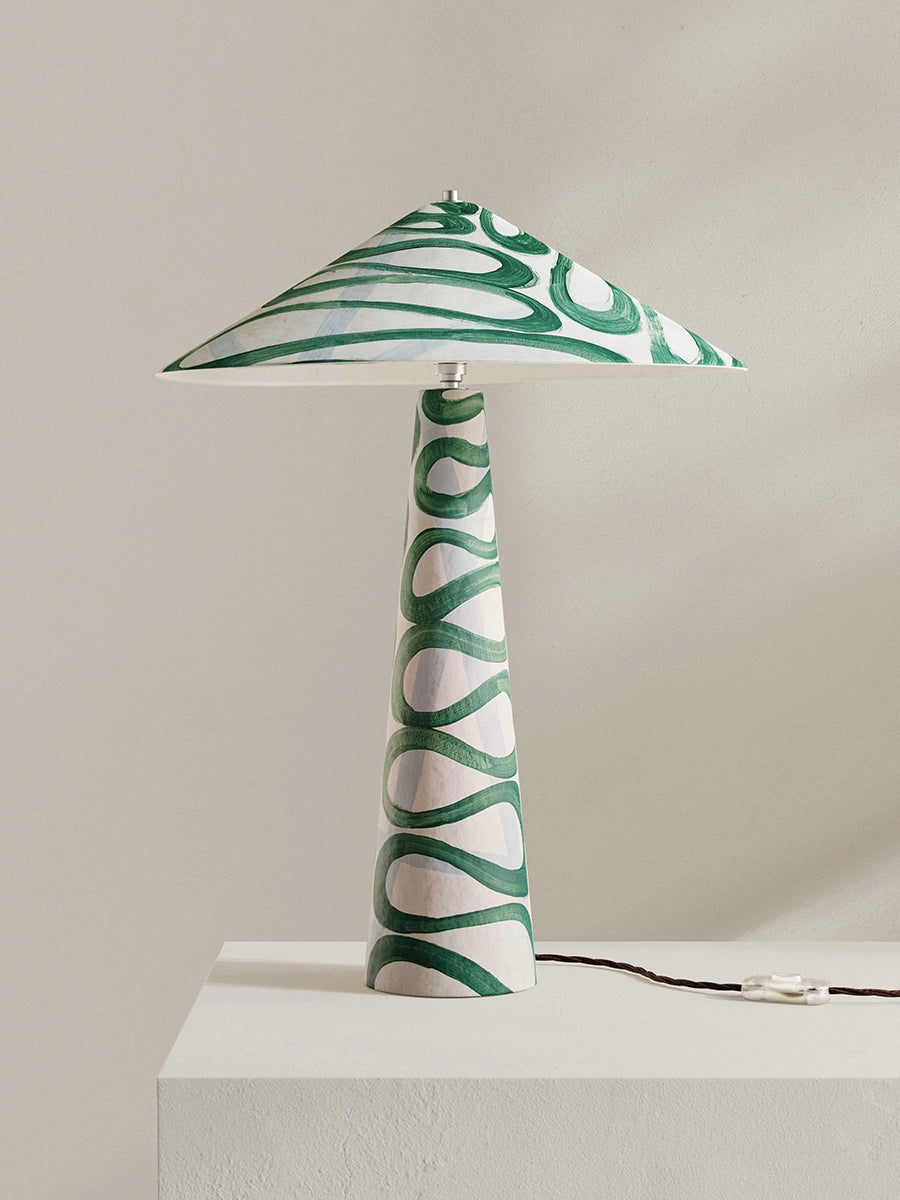 Decorative table lamp with green and white pattern on a neutral background