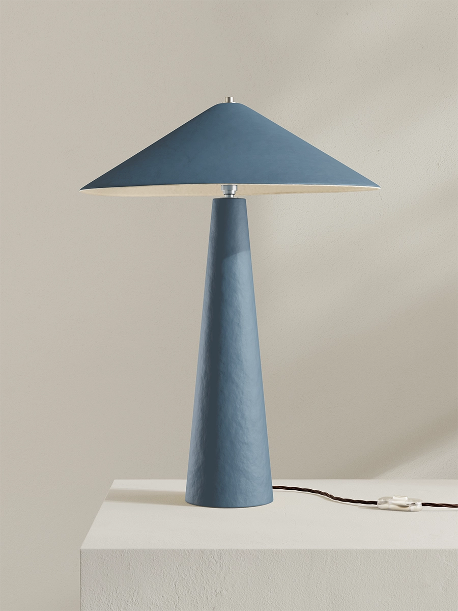 Blue table lamp with a conical base and rectangular shade on a neutral background