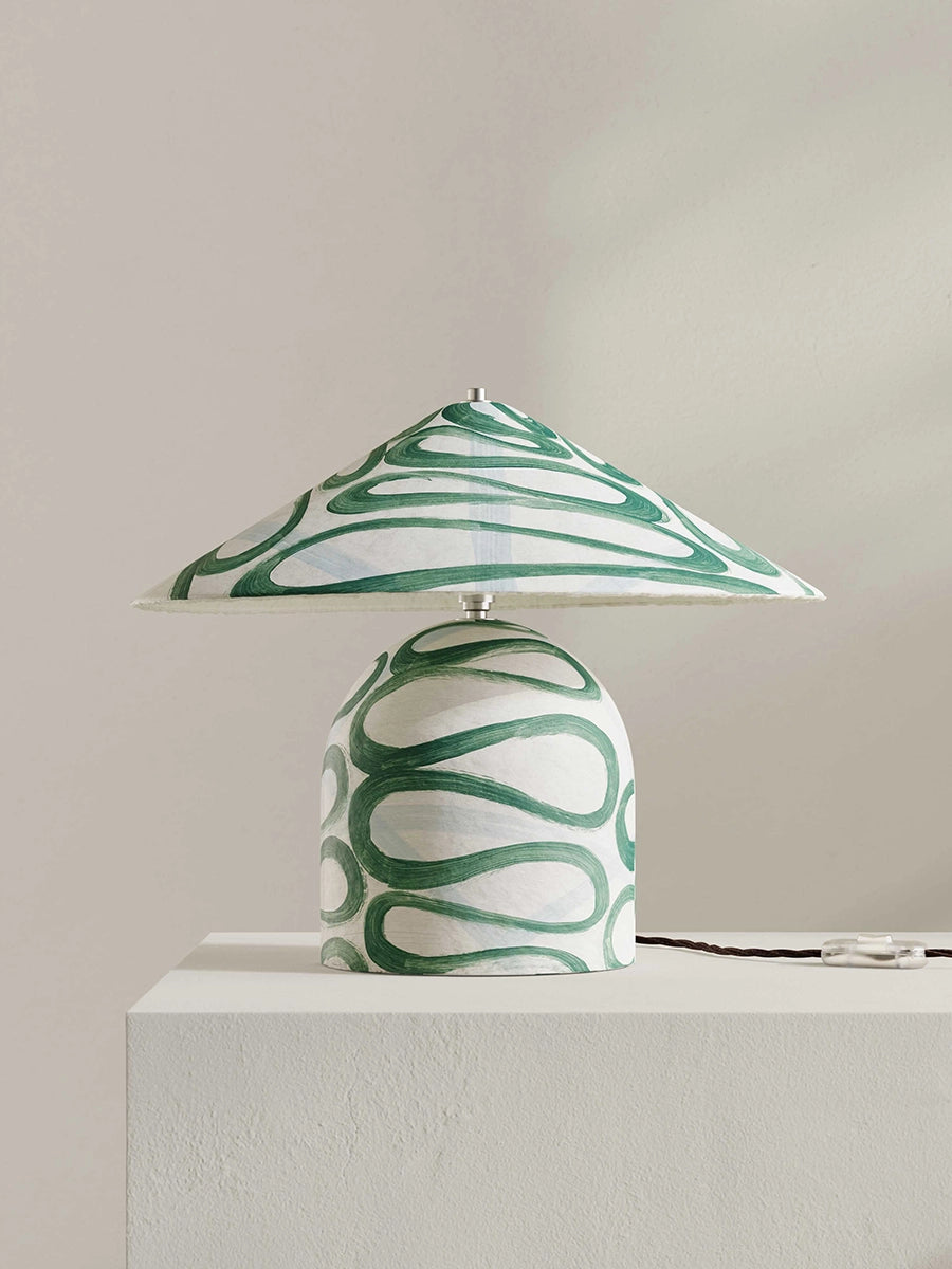 Table lamp with green and white design on a neutral background