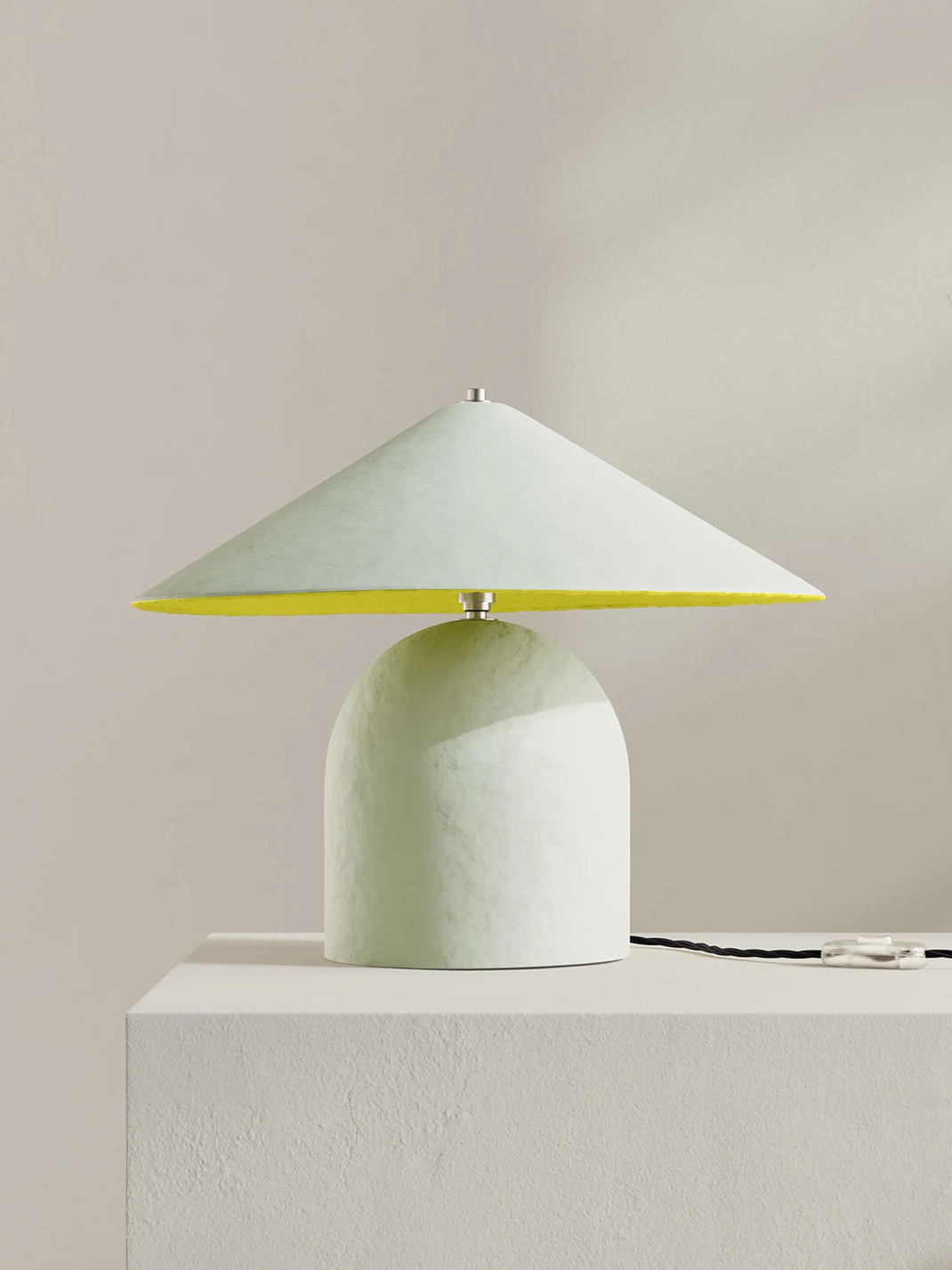 Table lamp with an off-white base and yellow lampshade on a white surface.