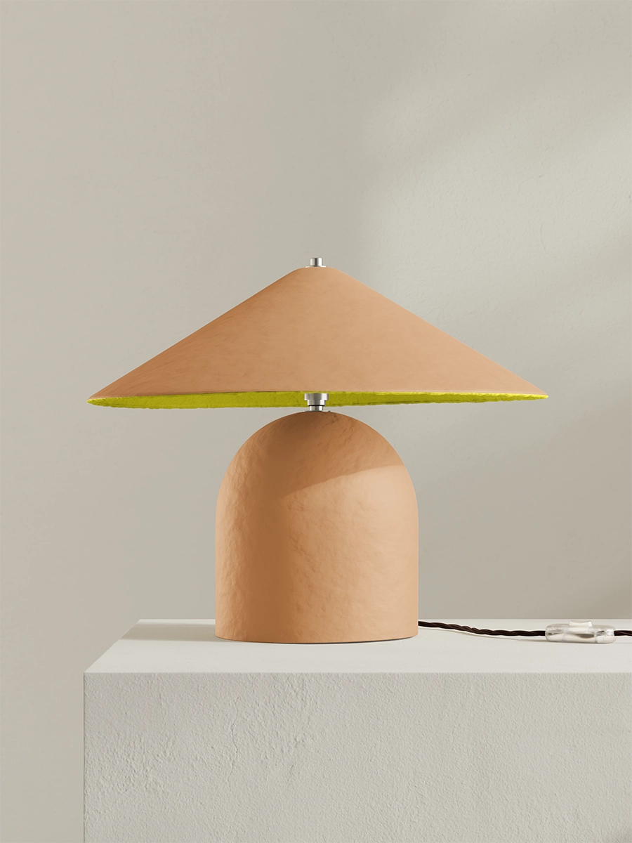 Table lamp with a yellow interior shade on a light gray surface.