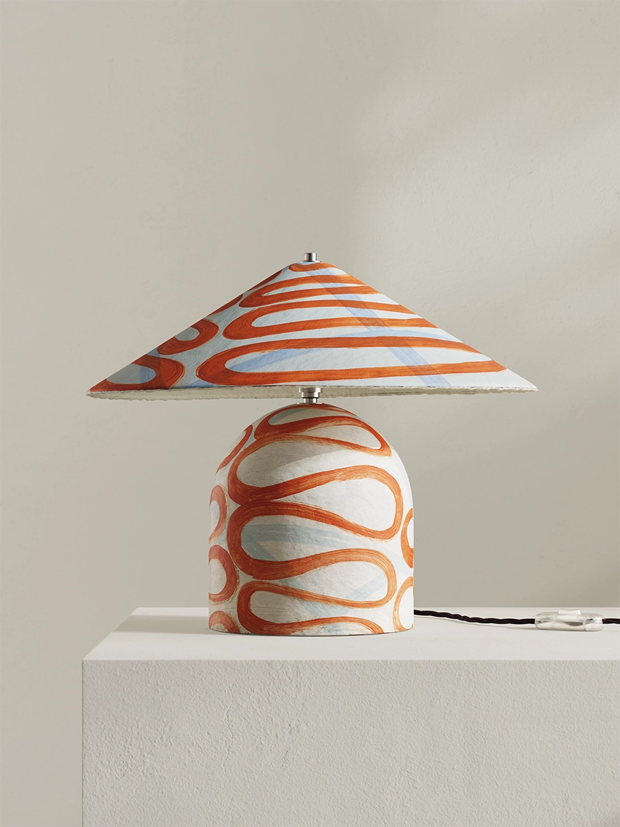 Table lamp with a colorful striped shade on a neutral background