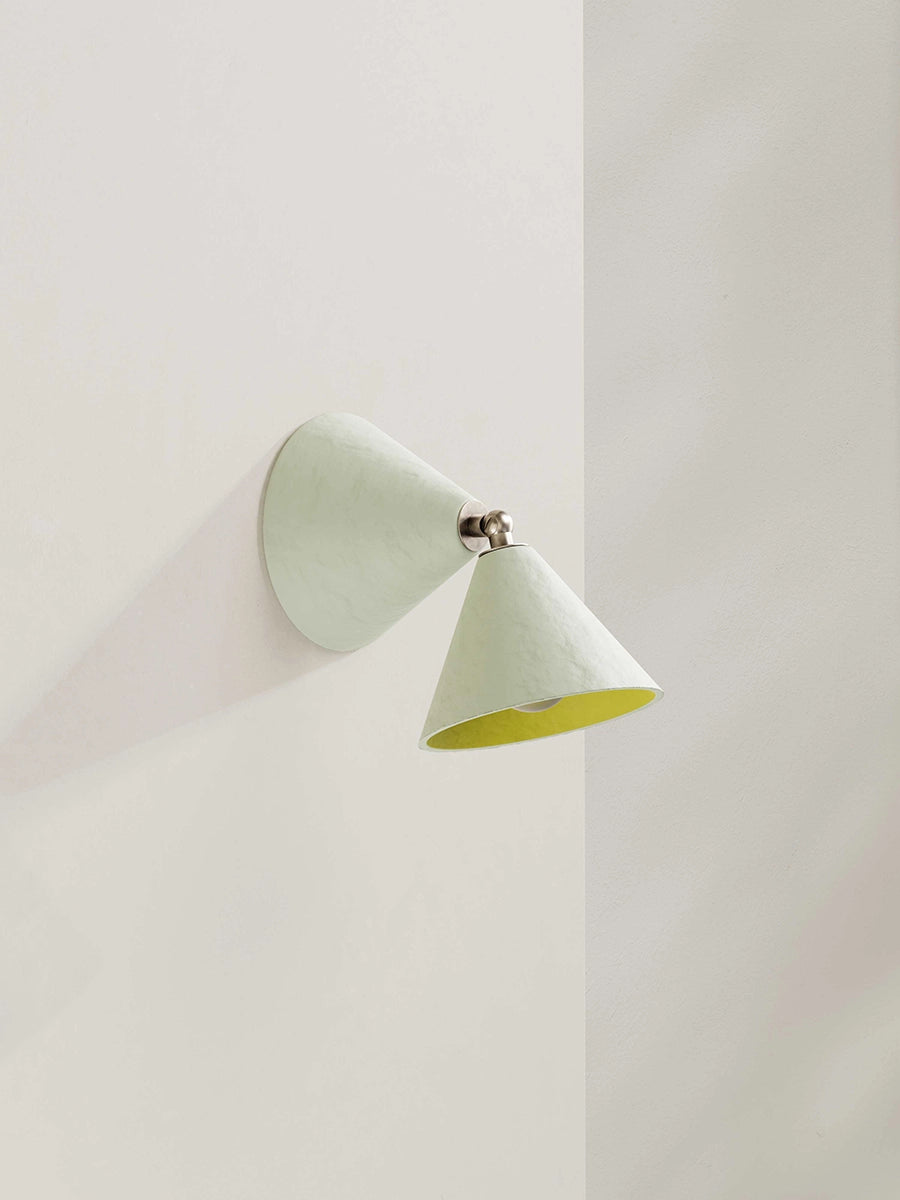 Modern wall lamp in white with a yellow interior on a white wall