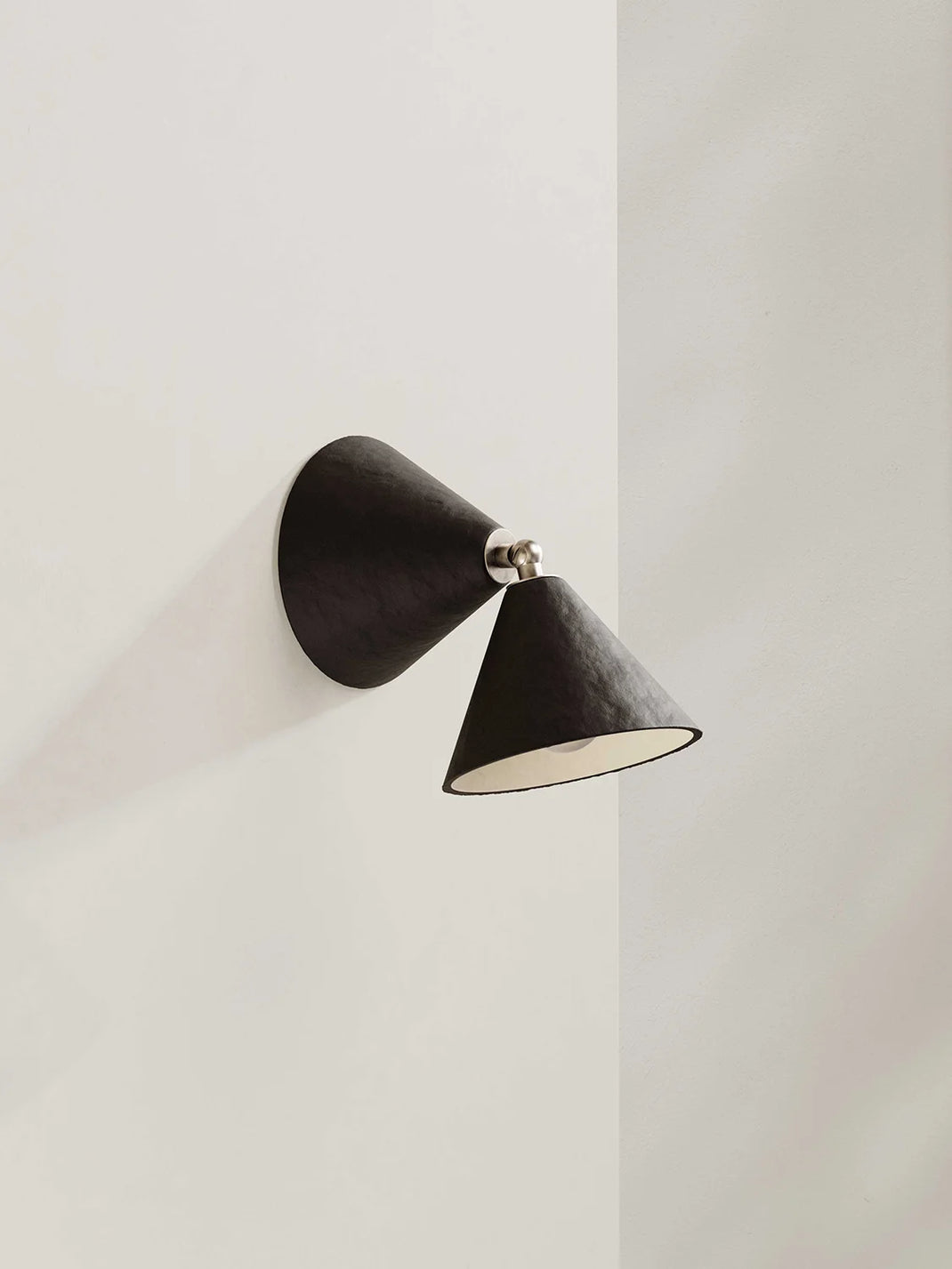 Dark brown wall-mounted lamp on a light gray wall