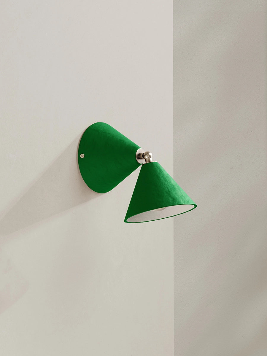Green wall lamp on a light gray wall