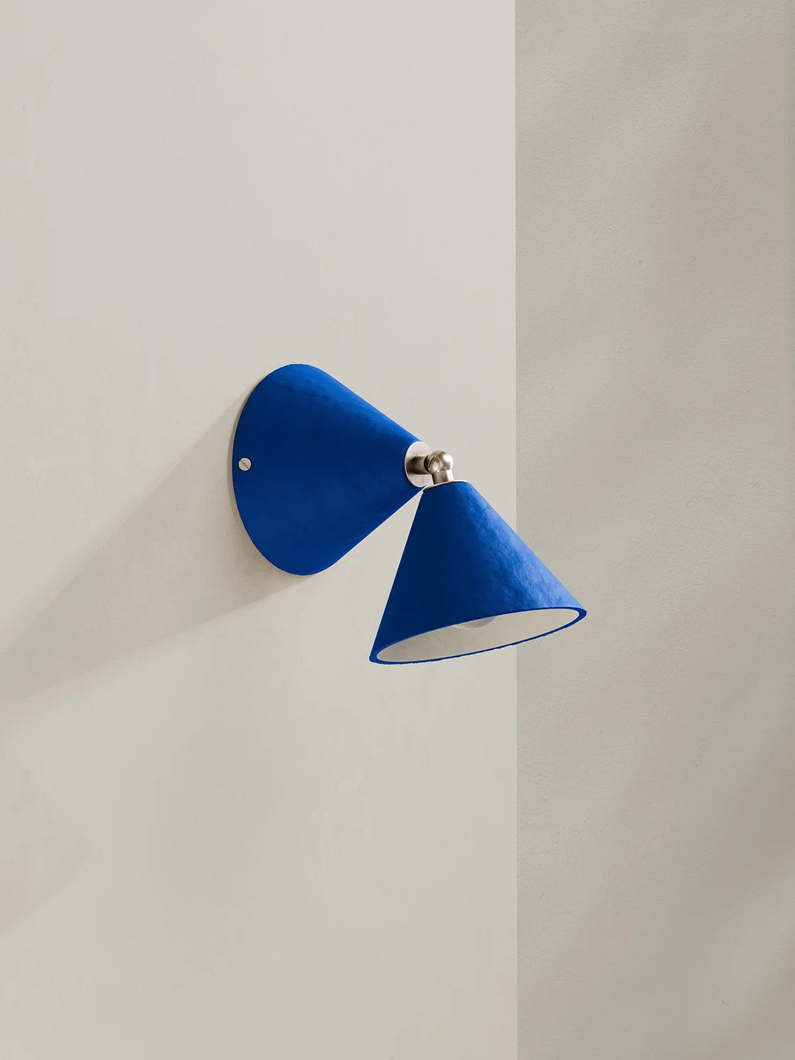 Blue wall sconce on a light gray wall