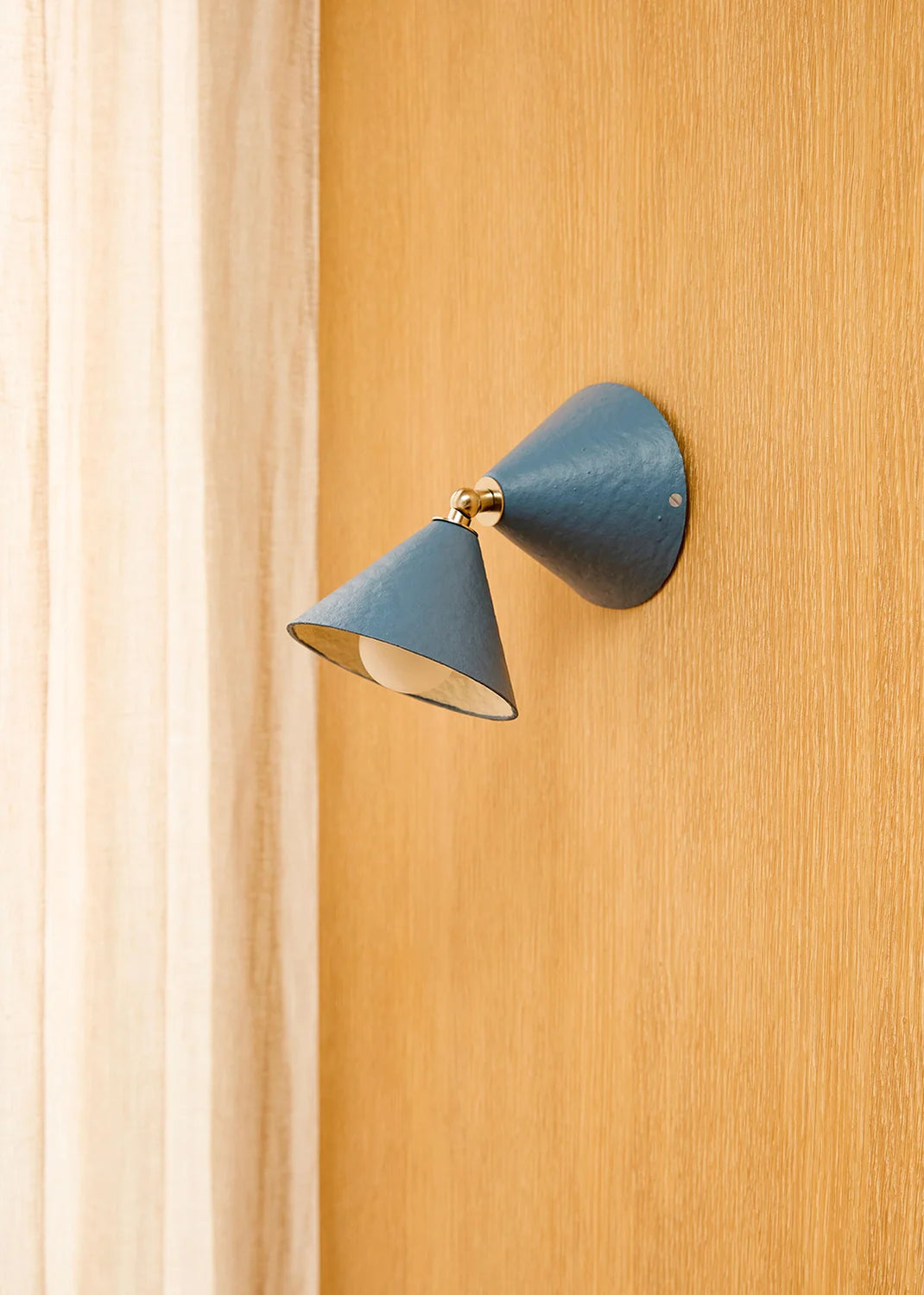 Blue wall-mounted lamp on a wooden panel