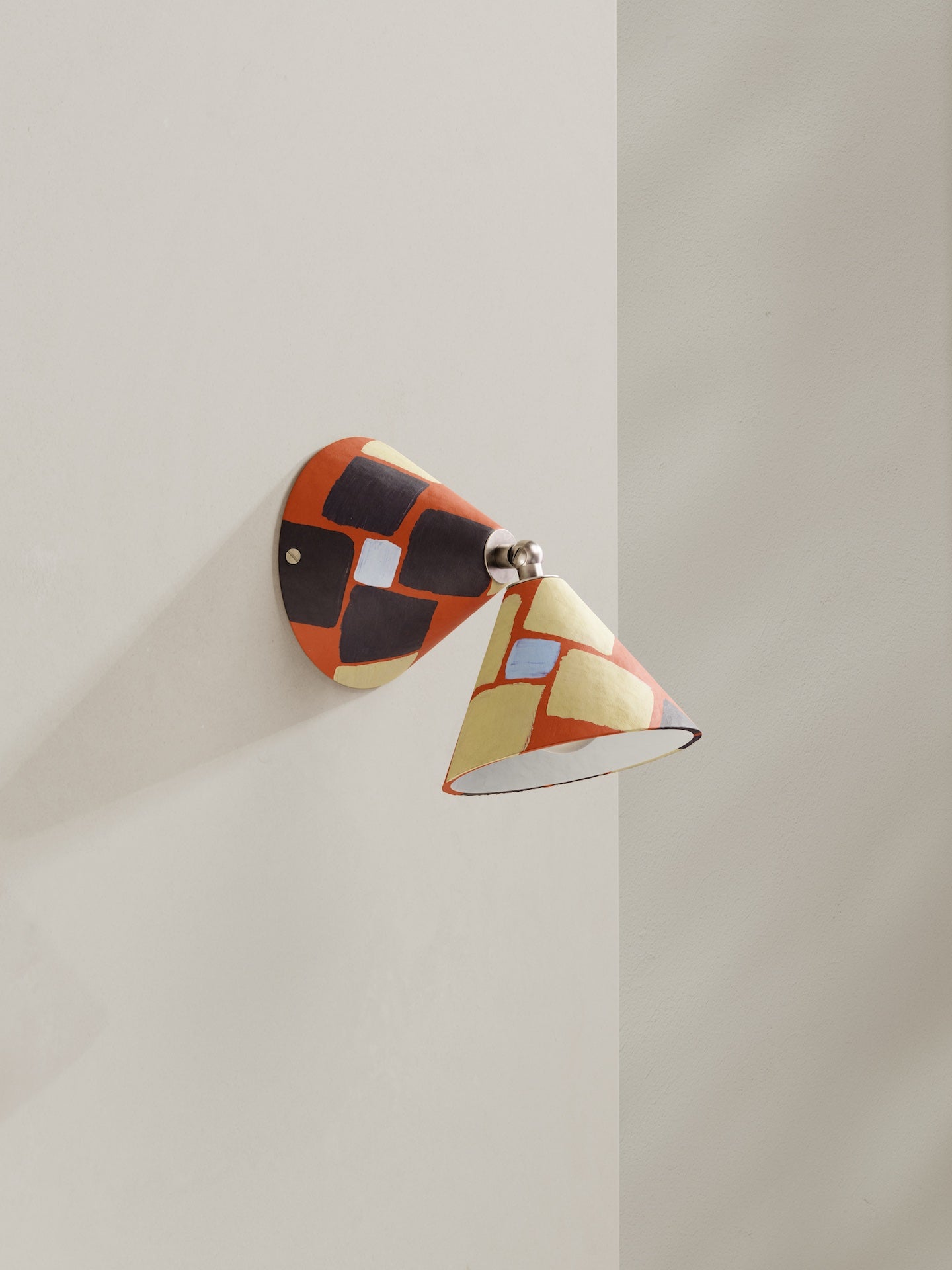 Hardwired Rotor wall light - a conical shaped wall light, in hand-painted paper pulp, mosaic pattern with orange base colour, brown and light blue and light yellow accents.