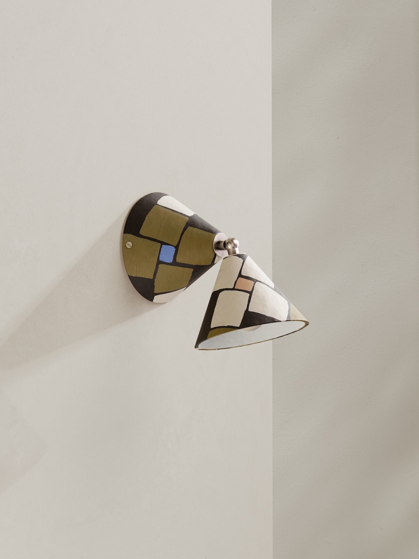 Hardwired Rotor wall light - a conical shaped wall light, in hand-painted paper pulp, mosaic pattern with dark brown base colour, blue, pink and cream accents.