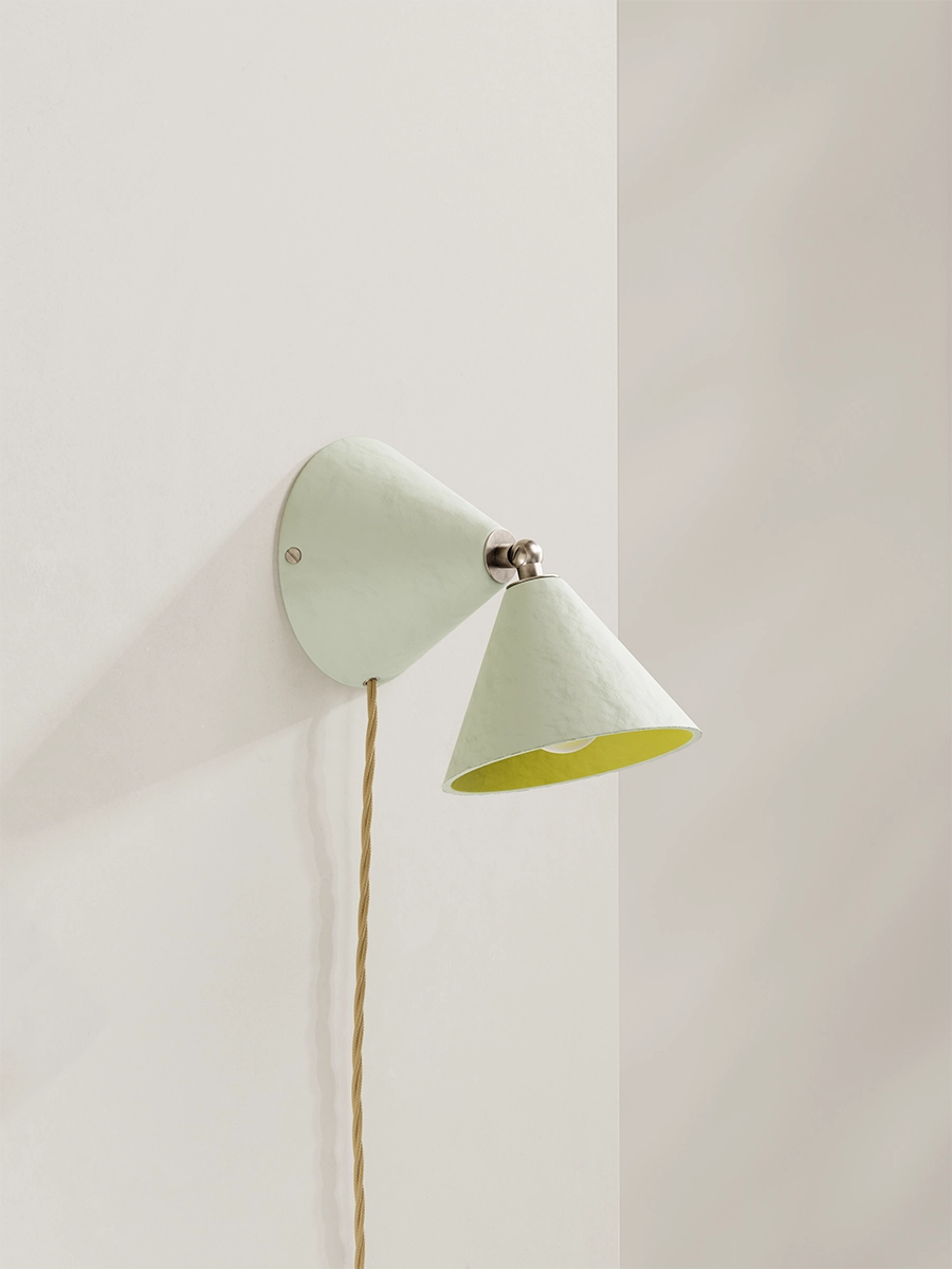 A white wall lamp yellow interior against a plain wall