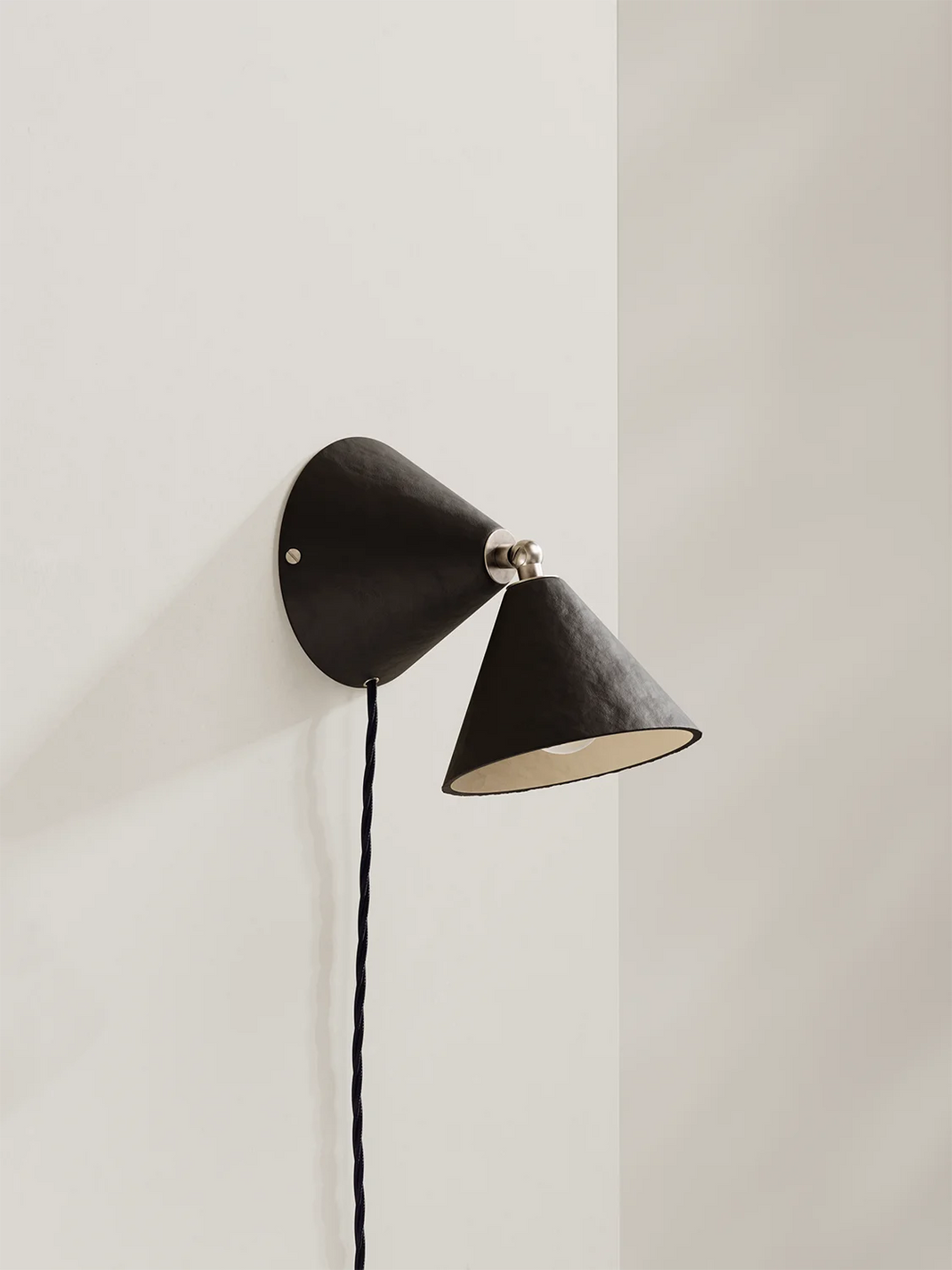 Modern wall lamp with dark brown cone-shaped shades on a neutral background
