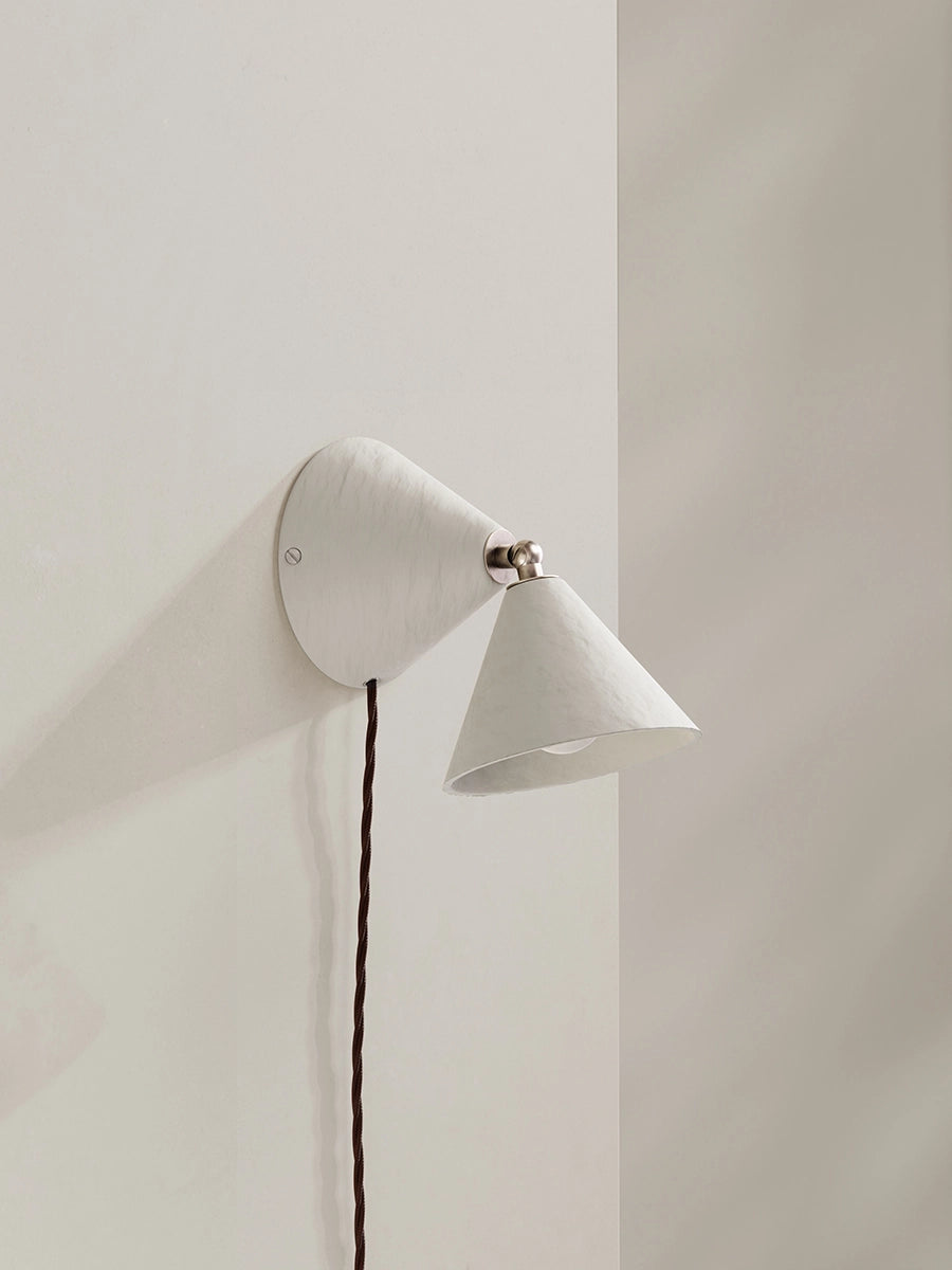 White wall lamp and brown flex against neutral background