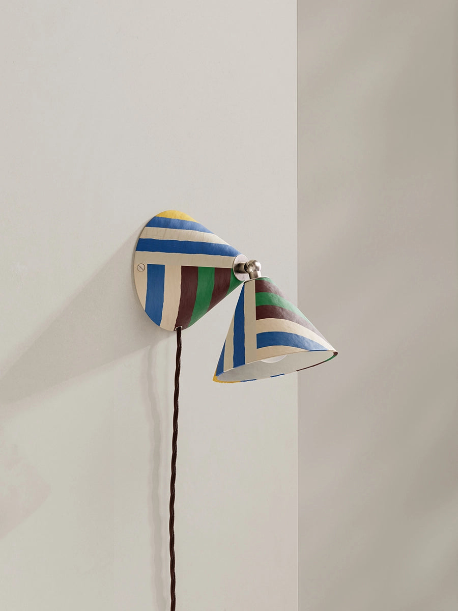 Striped wall lamp against a neutral back drop