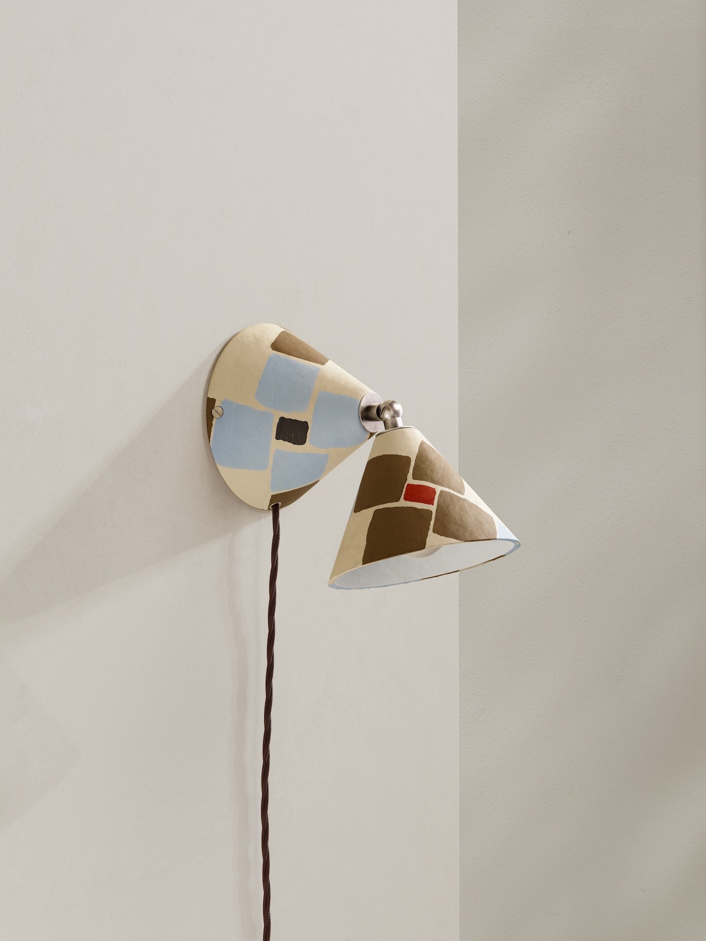Plug-in Rotor wall light - a conical shaped plug-in wall light, in hand-painted paper pulp, mosaic pattern with cream base colour and light blue, dark gold and orange accents and brown flex.